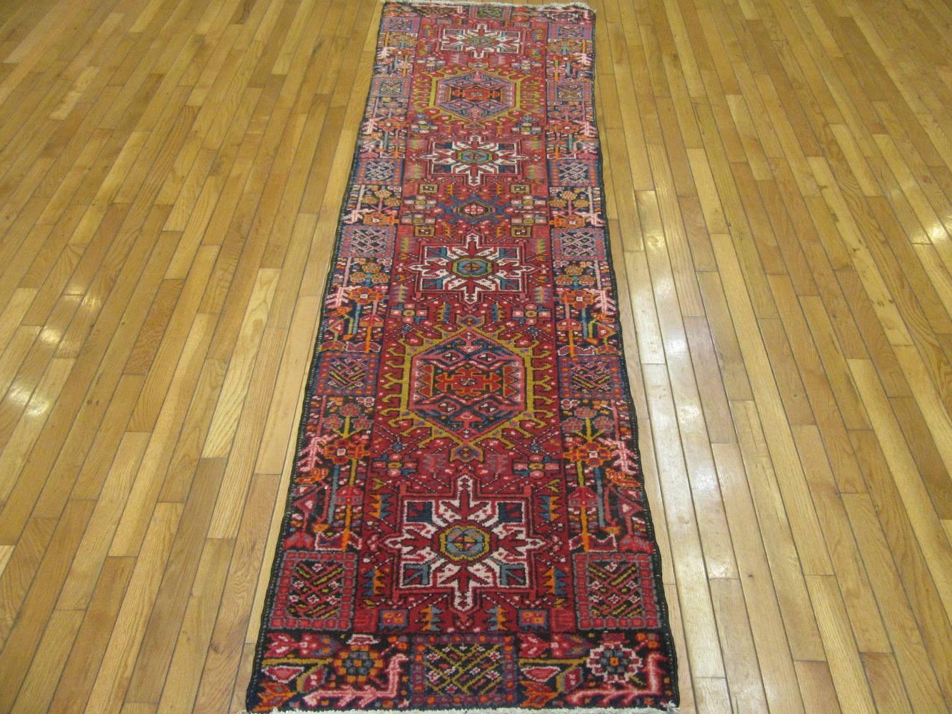 This is a short vintage hand-knotted wool Persian Karajeh runner rug. It has the trademark geometric multiple medallion design of the rugs from this village. It is in very good condition and measures 2' 5