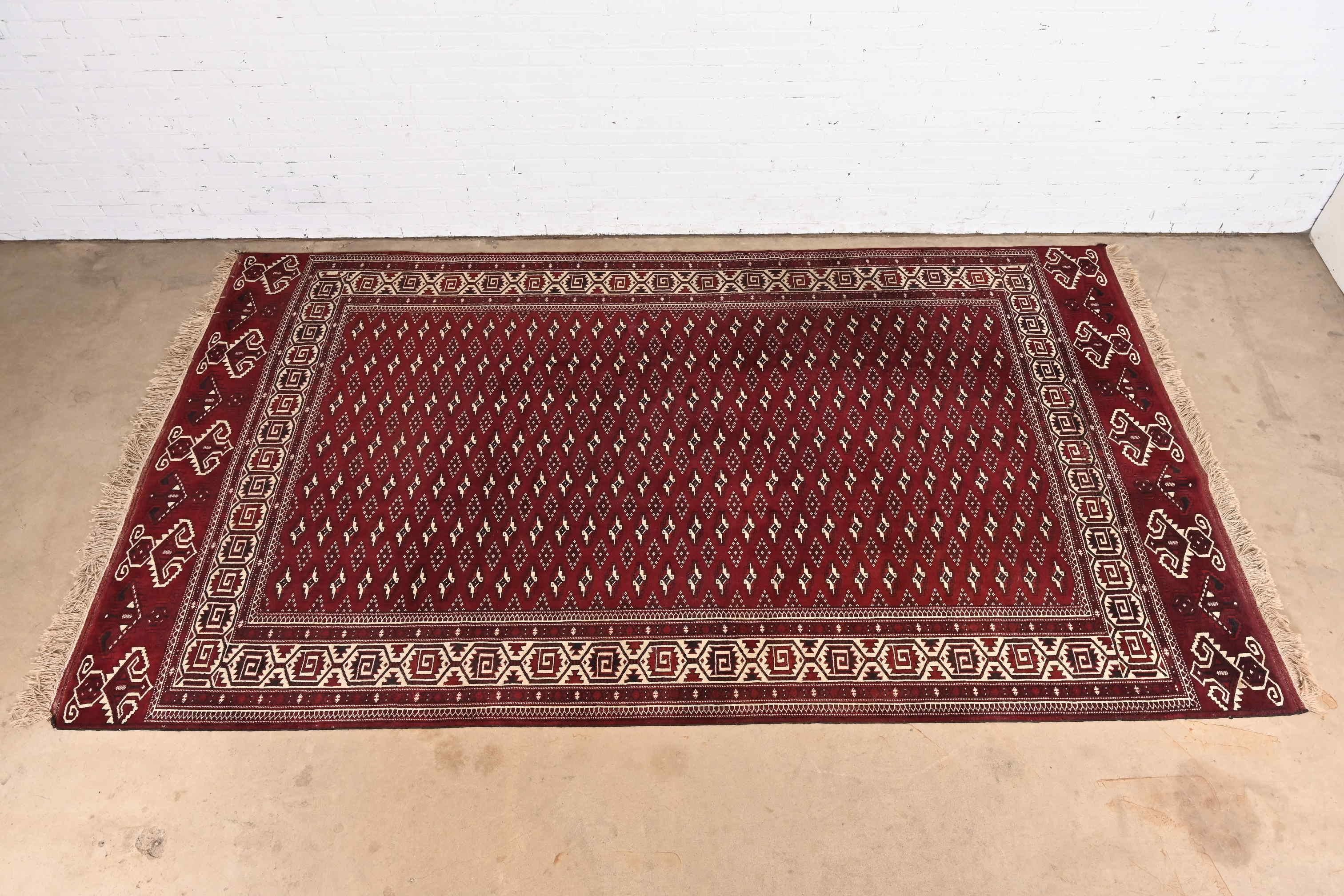 A gorgeous Mid-Century Modern hand-woven tribal Persian Bokhara room size wool rug

Mid-20th Century

Beautiful geometric design, with predominant colors in burgundy, ivory, and black.

Measures: 7'3