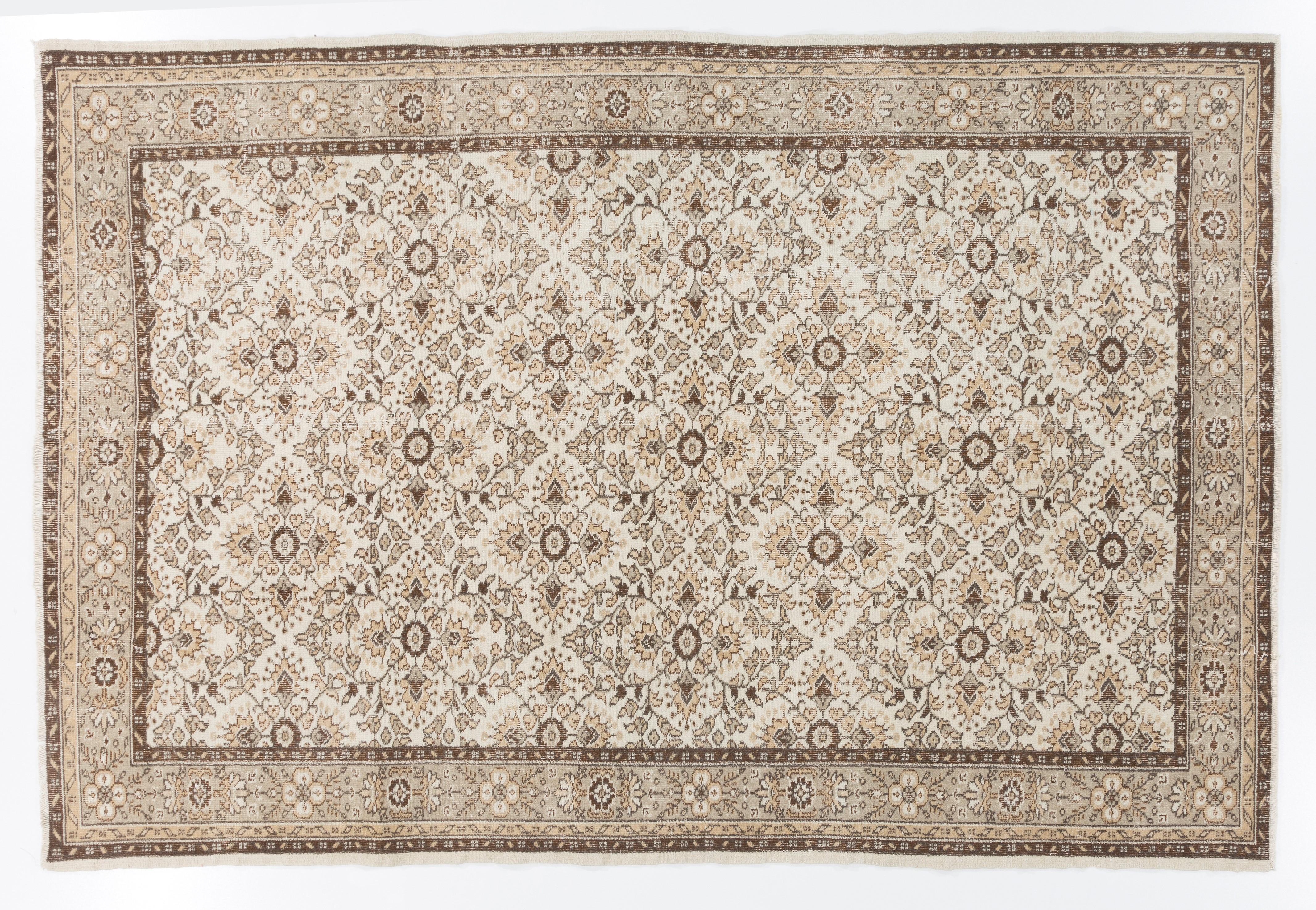 This vintage hand knotted Turkish area rug was made in the 1960s. It has low wool pile on cotton foundation. It is sturdy, in good condition and clean. It features an all-over design of latticed stylized floral heads in quatrefoil format. The color