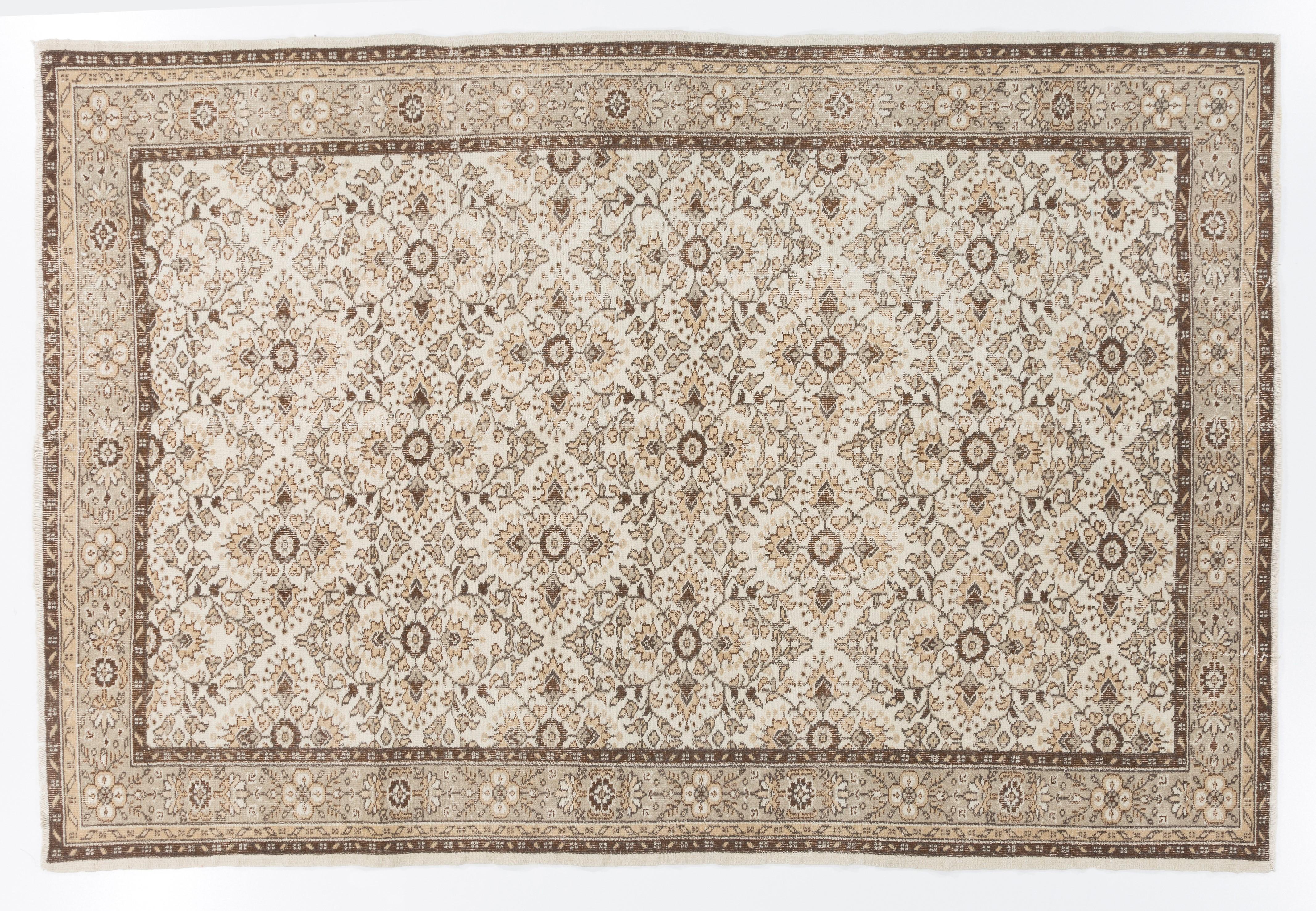 This vintage hand knotted Turkish area rug was made in the 1960s. It has low wool pile on cotton foundation. It is sturdy, in good condition and clean. It features an all-over design of latticed stylized floral heads in quatrefoil format. The color