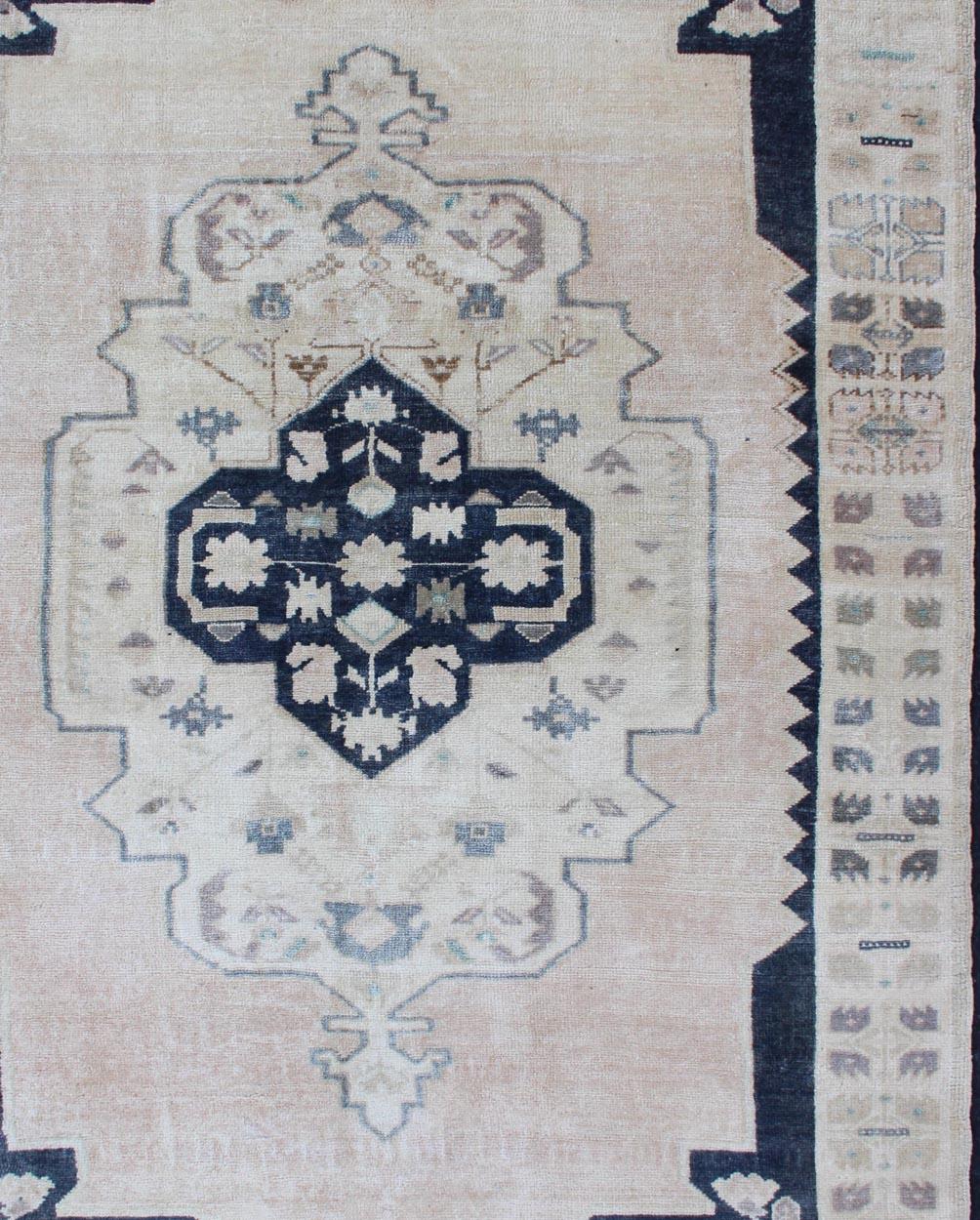 Faded vintage Turkish Oushak rug with central medallion in cream and blue, Keivan Woven Arts / rug EN-179354, country of origin / type: Turkey / Oushak, circa 1940

This sublime and enchanting vintage rug, a gorgeous Oushak rug made in Turkey