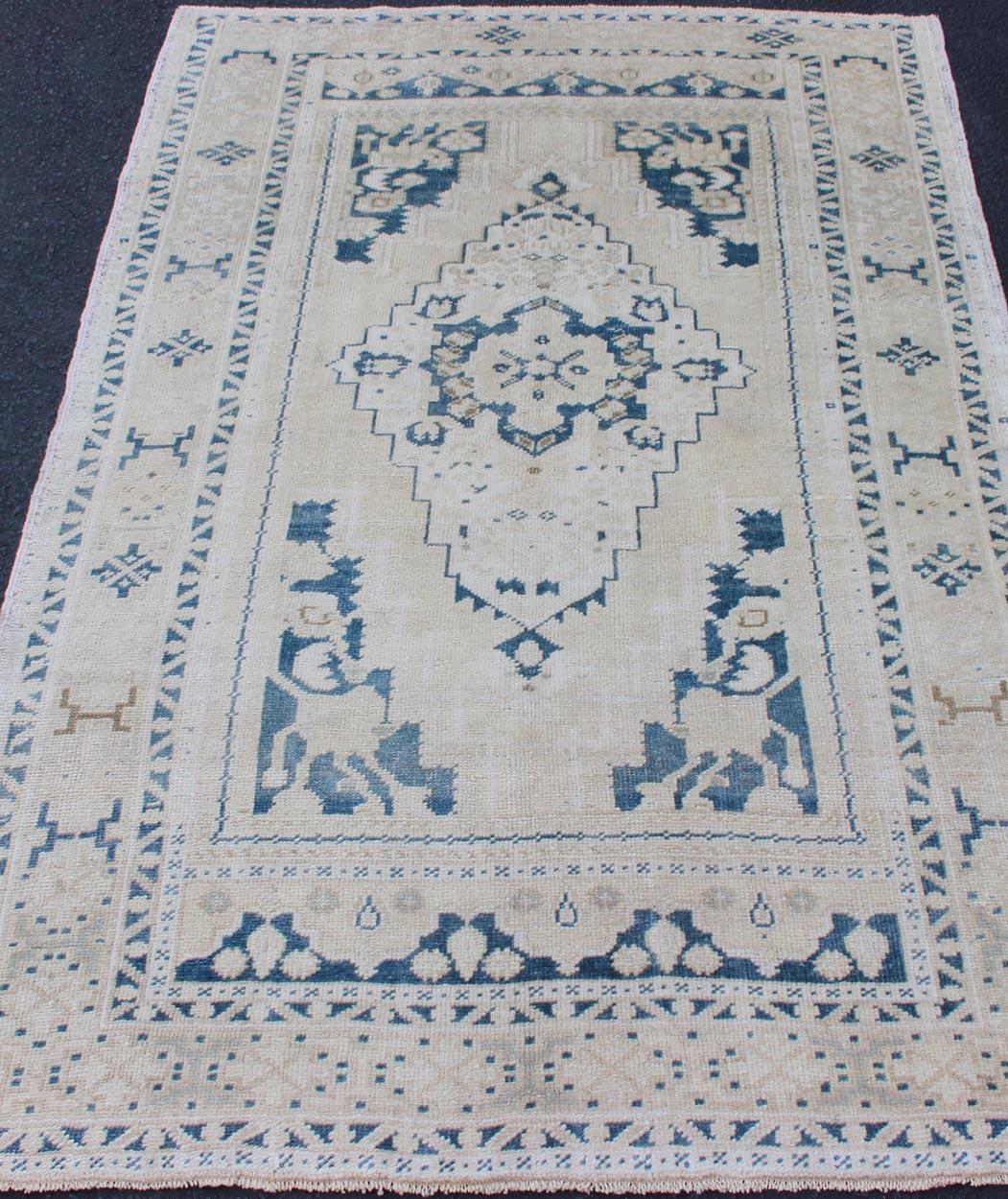 20th Century Vintage Hand Knotted Turkish Oushak Rug with Central Medallion in Blue and Cream For Sale
