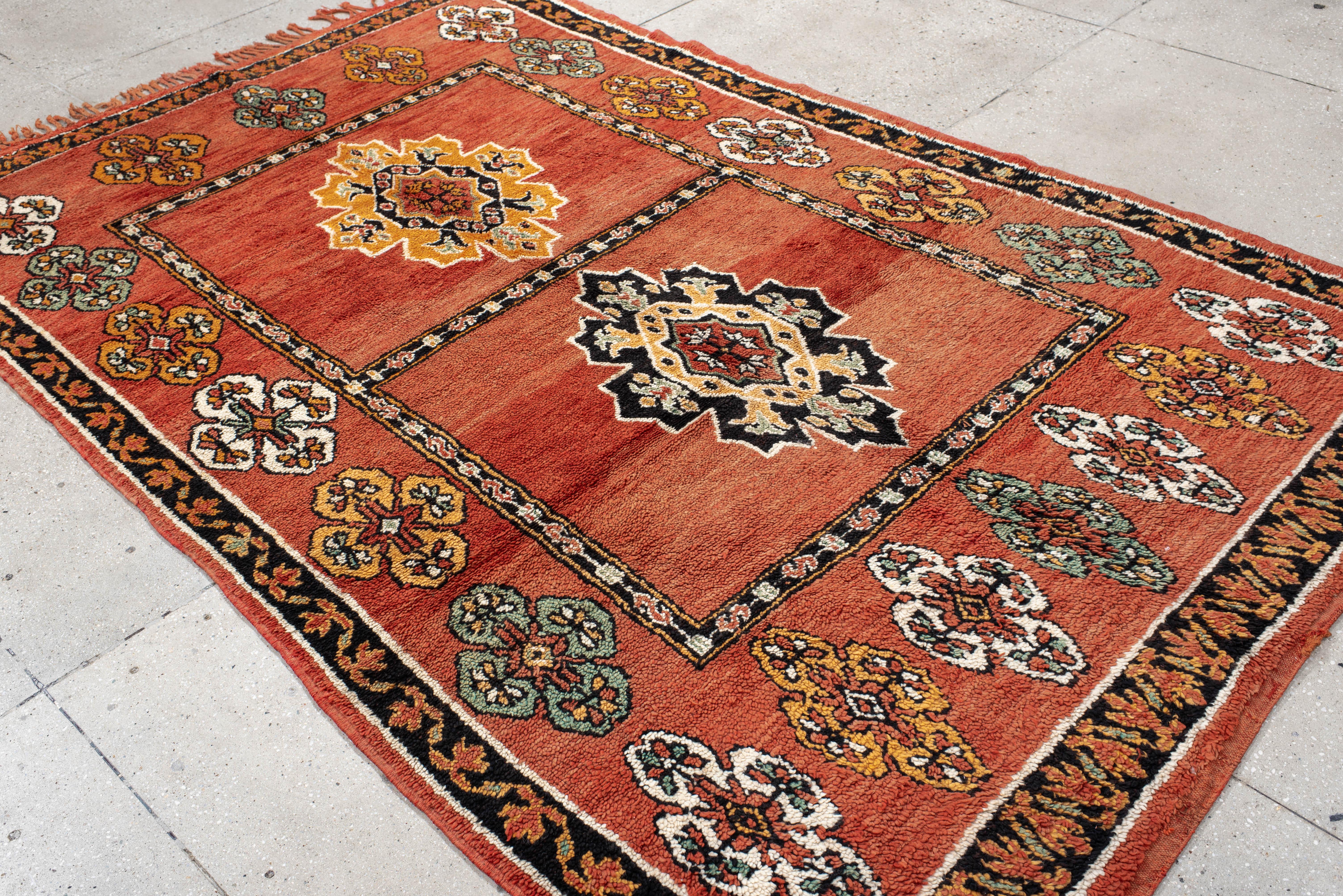 This vintage Turkish rug features a bold twin-medallion layout framed within a rectangular panel format. The rust-colored field is enriched with floral borderwork and boteh-style corner motifs in soft teal, ivory, and saffron, creating a structured