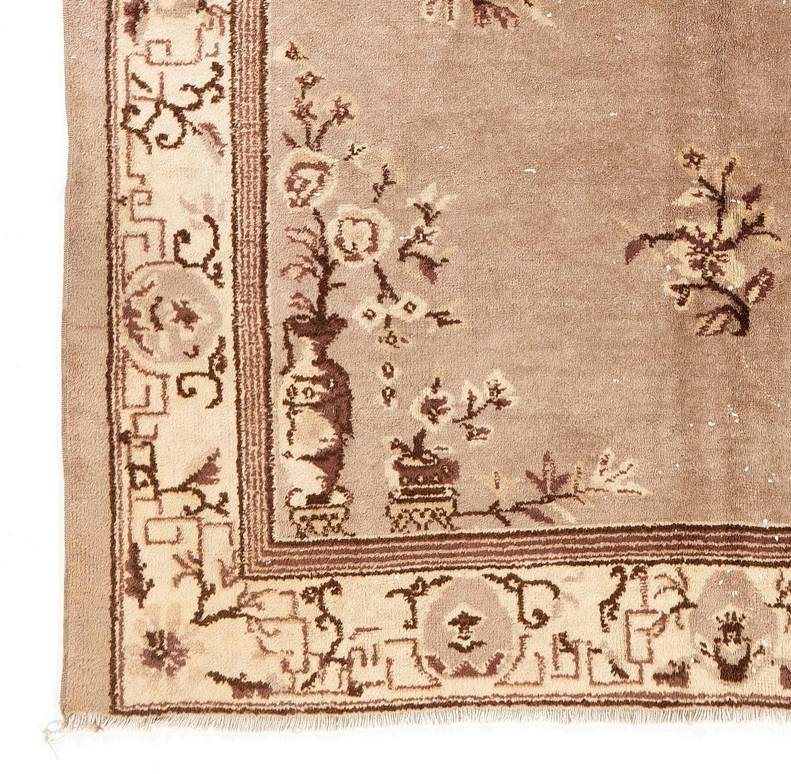 Ein alter handgeknüpfter chinesischer Teppich mit einem zentralen Medaillonmuster, das Rosetten und eckige Blätter in Stahl mit braunen Akzenten auf einem verblassten taupefarbenen Feld zeigt. 

Die braunen Umrisse der Rosetten sowie die mäandernden