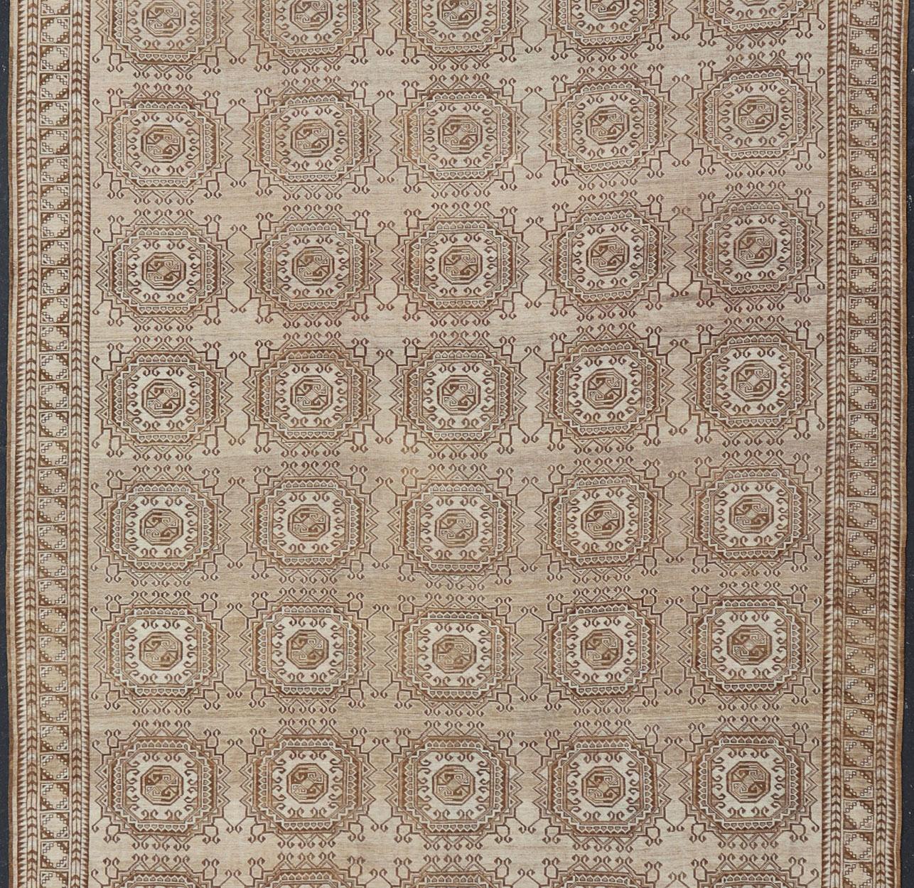 Dieser handgeknüpfte türkische Vintage-Teppich zeichnet sich durch ein sich wiederholendes, subgeometrisches achteckiges Design in elfenbeinfarbenen und erdigen Tönen aus, das diesen Teppich perfekt für eine Vielzahl von klassischen, lässigen,