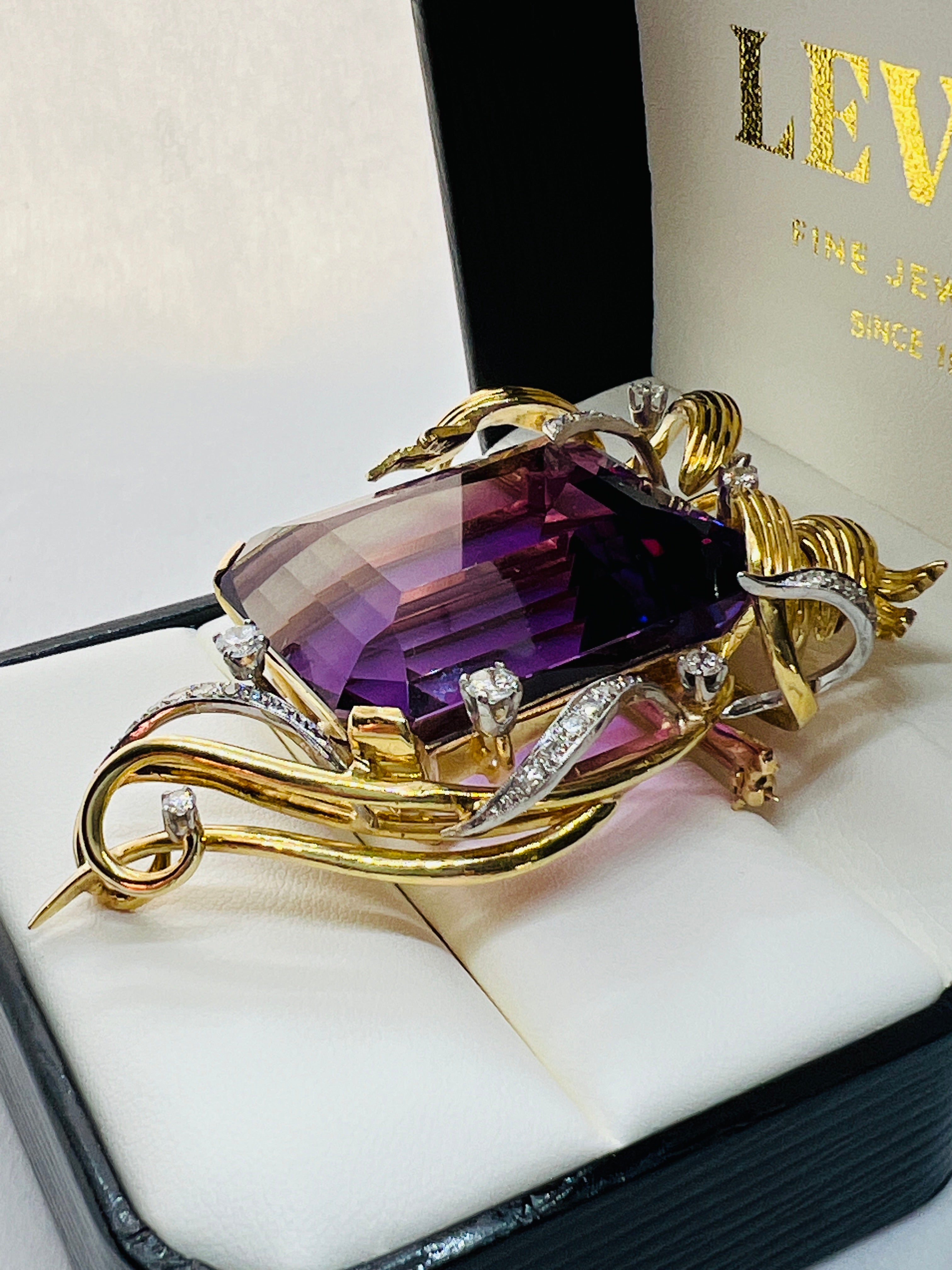 Absolutely StunningBrooch! This is a handmade Vintage piece that features a beautiful 130 carat amethyst at the center that measures 1 inch by 1.25 inch.  The amethyst is surrounded by ribbons of 18K yellow Gold as well as ribbons of diamonds. There