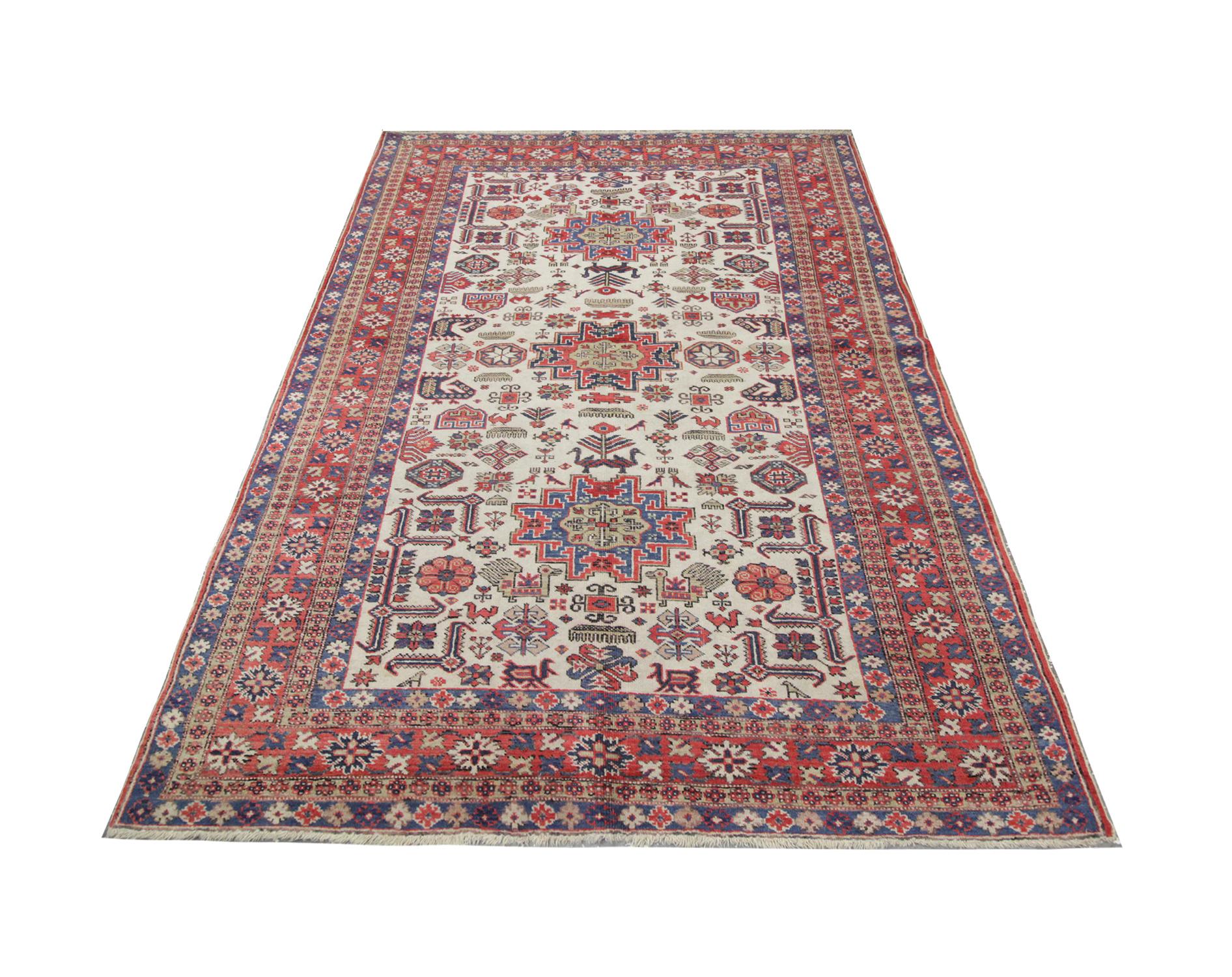 Bright colors have been used to construct this large, vintage area rug. Blues and reds have been woven intricately with a multi-layered floral and geometric border which encompasses the central design. The centre features three beautiful geometric
