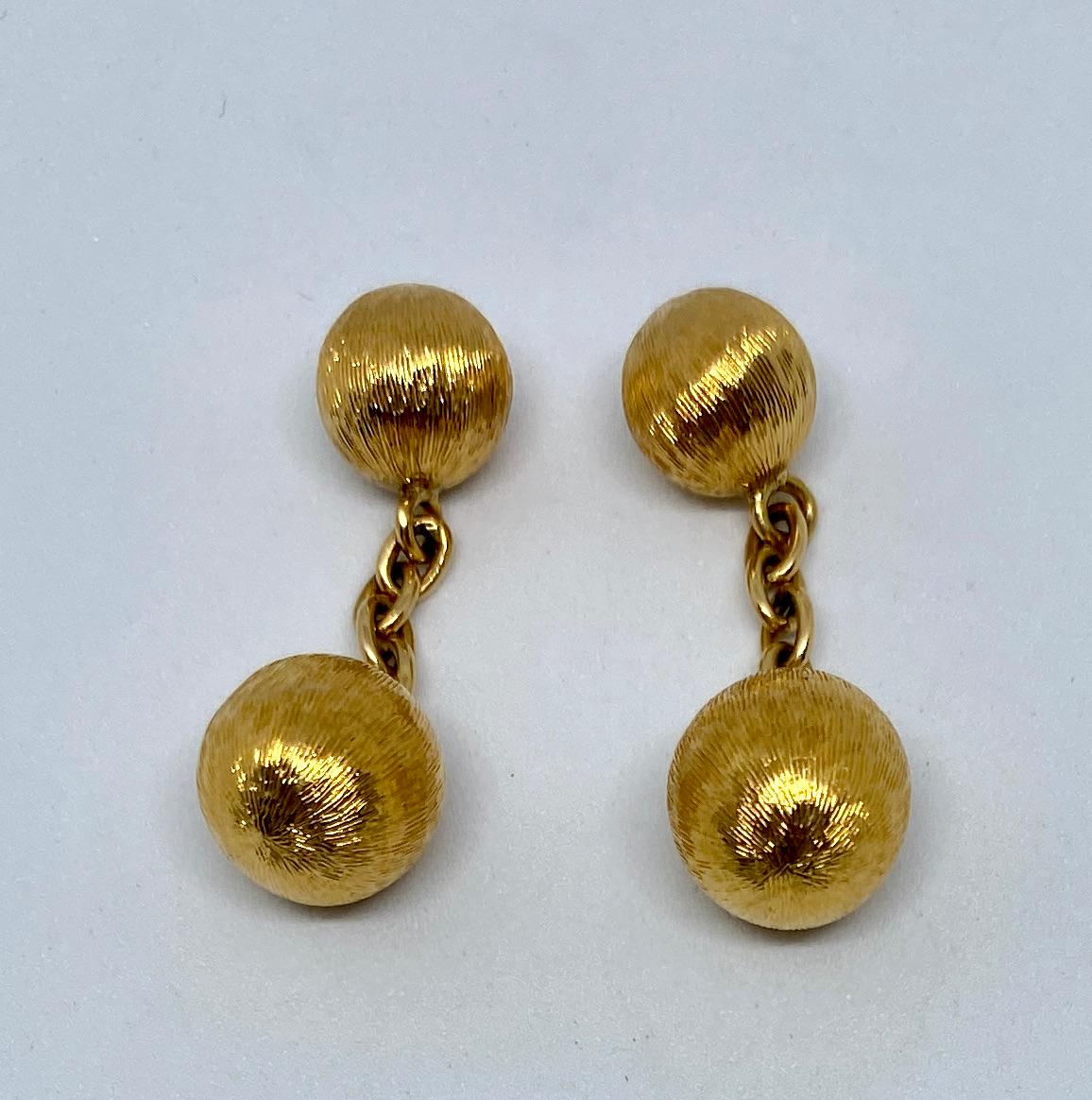 Fantastic, simple, tasteful cufflinks in 18K yellow gold with a Florentine finish that catches the light beautifully.

The larger spheres measure 10.5 mm in diameter; the smaller ones measure 8.7 mm. They're joined by 18K yellow gold chains.

These