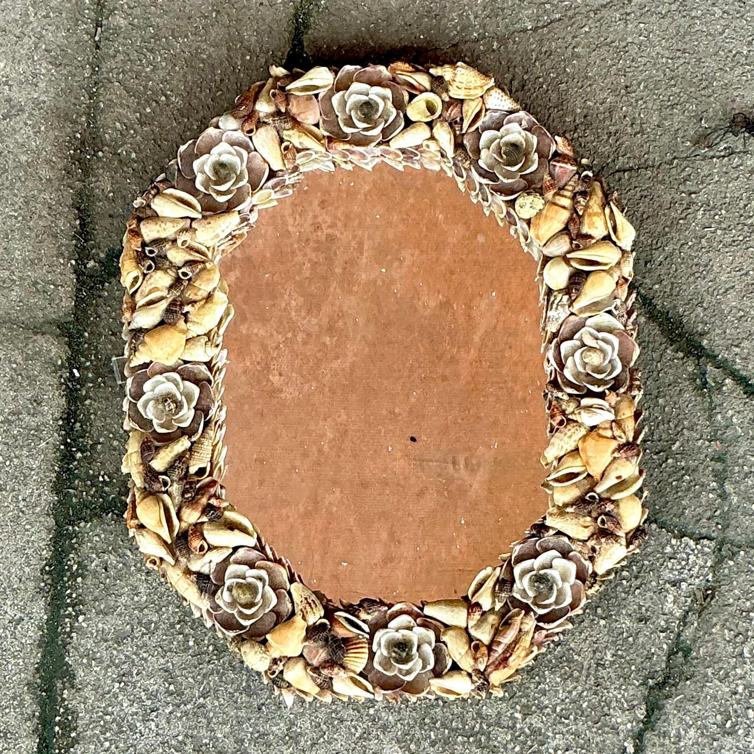 Apportez un charme côtier à votre espace avec ce miroir vintage en forme de coquillage fait à la main. Ornée de coquillages naturels méticuleusement disposés, cette pièce unique capture l'essence de la beauté du bord de mer. Chaque coquille est