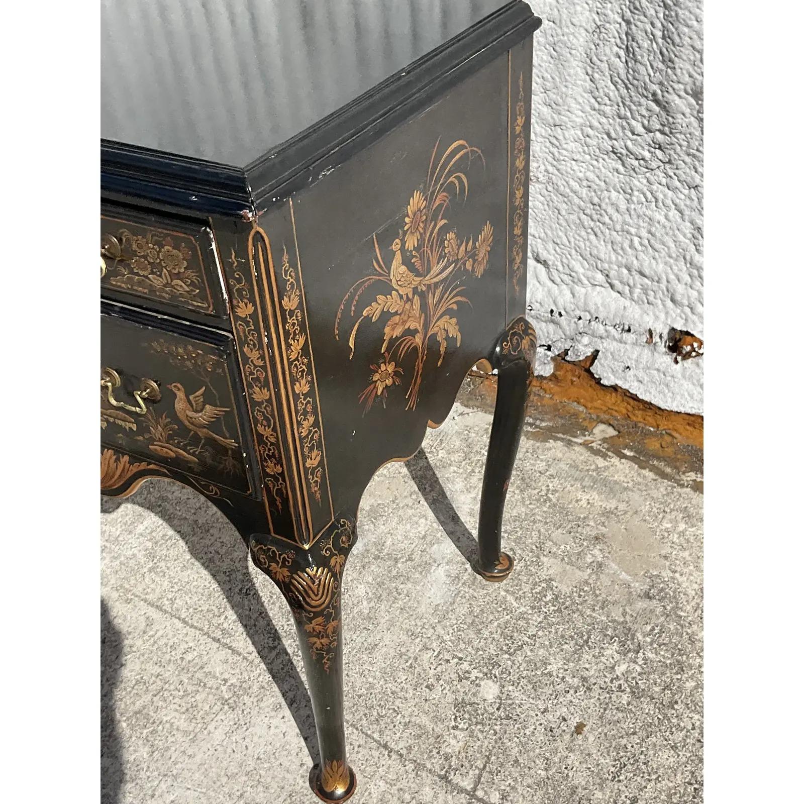 A fantastic vintage Asian Chinoiserie lowboy. Beautiful black lacquered finish with hand painted gilt classic pastoral scenes. Incredible attention to detail. Acquired from a Palm Beach estate.