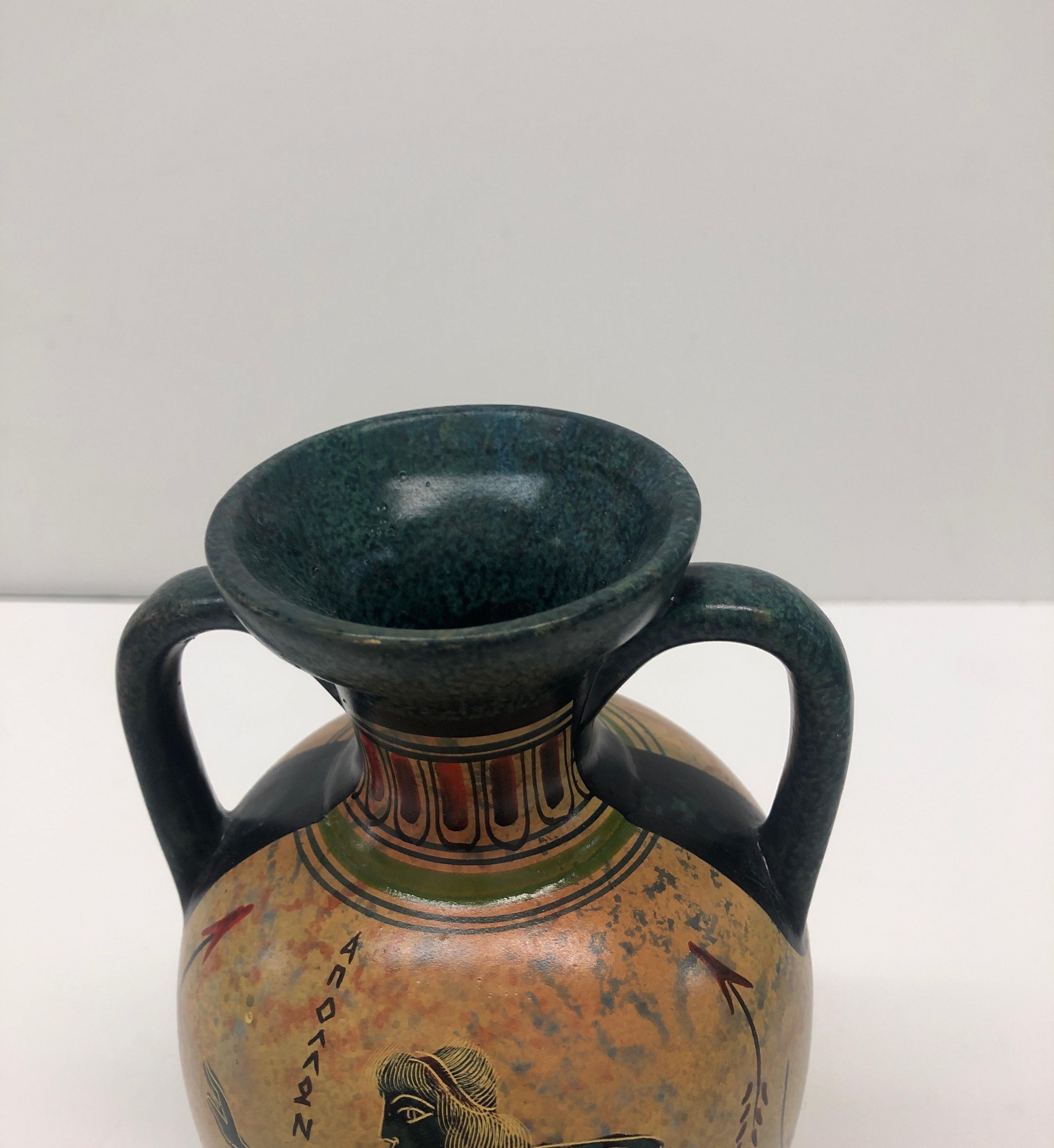 Vintage hand painted Greek amphora.
Size: 4” D x 7” H.