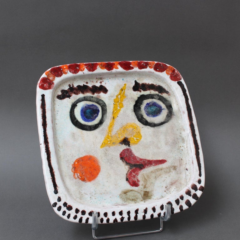 Vintage hand-painted Italian ceramic decorative platter by Giovanni DeSimone (1969). One of two platters on hand in the gallery (one is the face of a woman and the other, a man), this piece exemplifies his use of vivid colour as a pottery trademark.