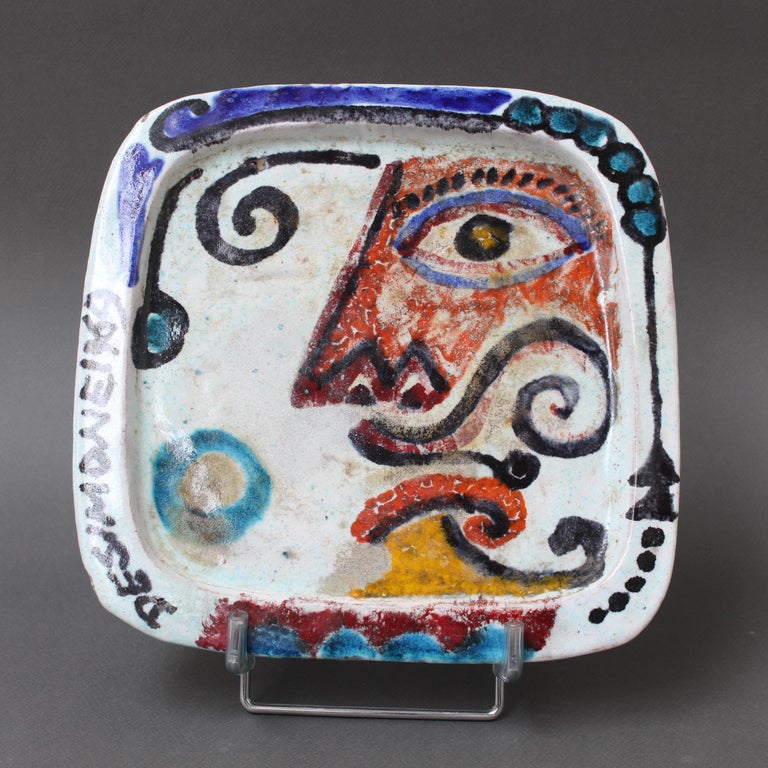 Vintage hand-painted Italian ceramic decorative platter by Giovanni DeSimone (1969). One of two platters on hand in the gallery (one is the face of a man and the other, a woman), this piece exemplifies his use of vivid colour as a pottery trademark.