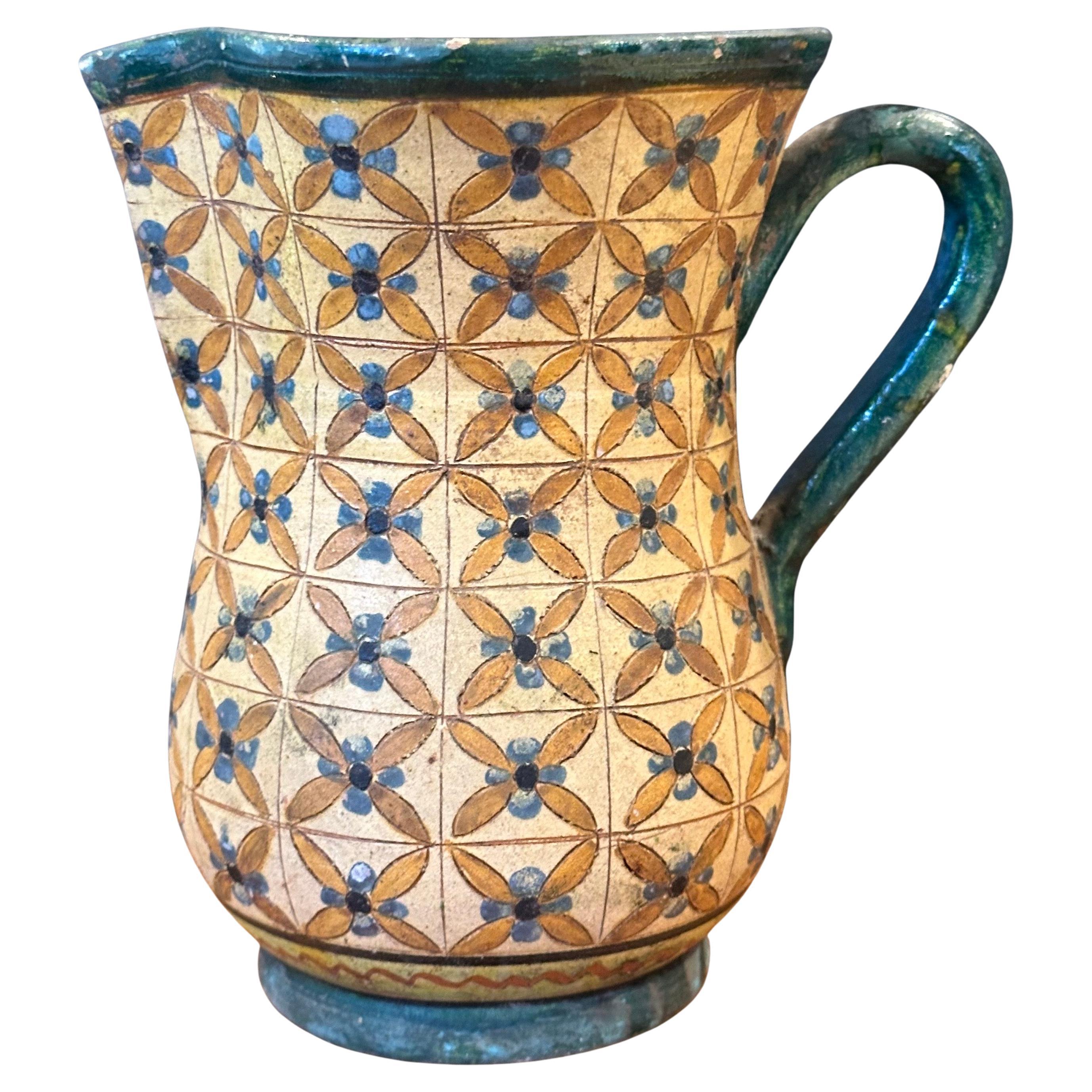 Vintage hand-painted Italian pottery water pitcher by Montopola Arno, circa 1960s.  The piece is in good vintage condition with expected wear and a few small dings and chips.  It measures 8