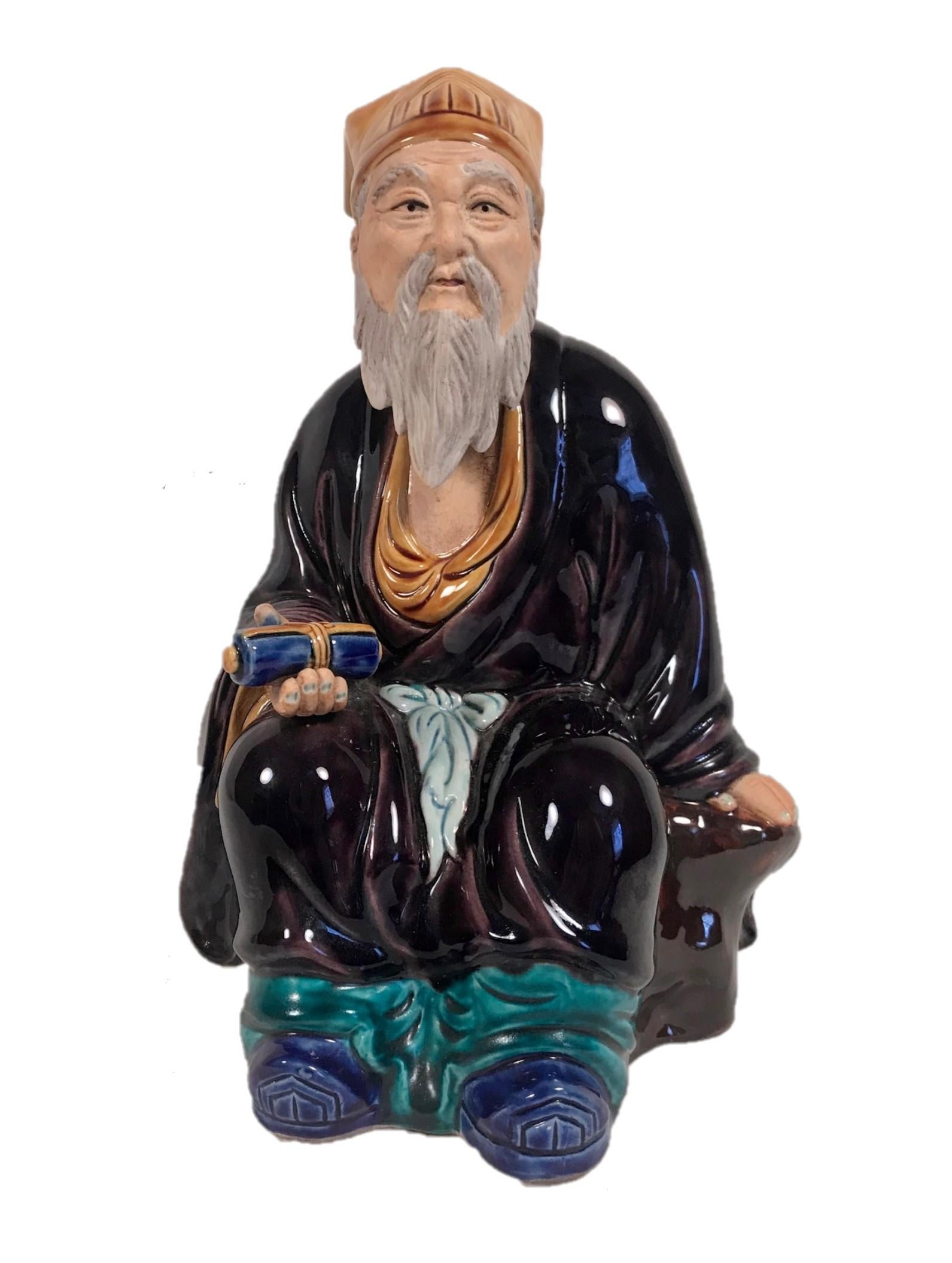 Vintage hand painted large 12” Chinese Mudman figure

This spectacular, high quality large mudman is for the advanced collector. It depicts a seated elder; a bearded scholar holding a scroll in his hand. He is dressed in a robe and wearing a
