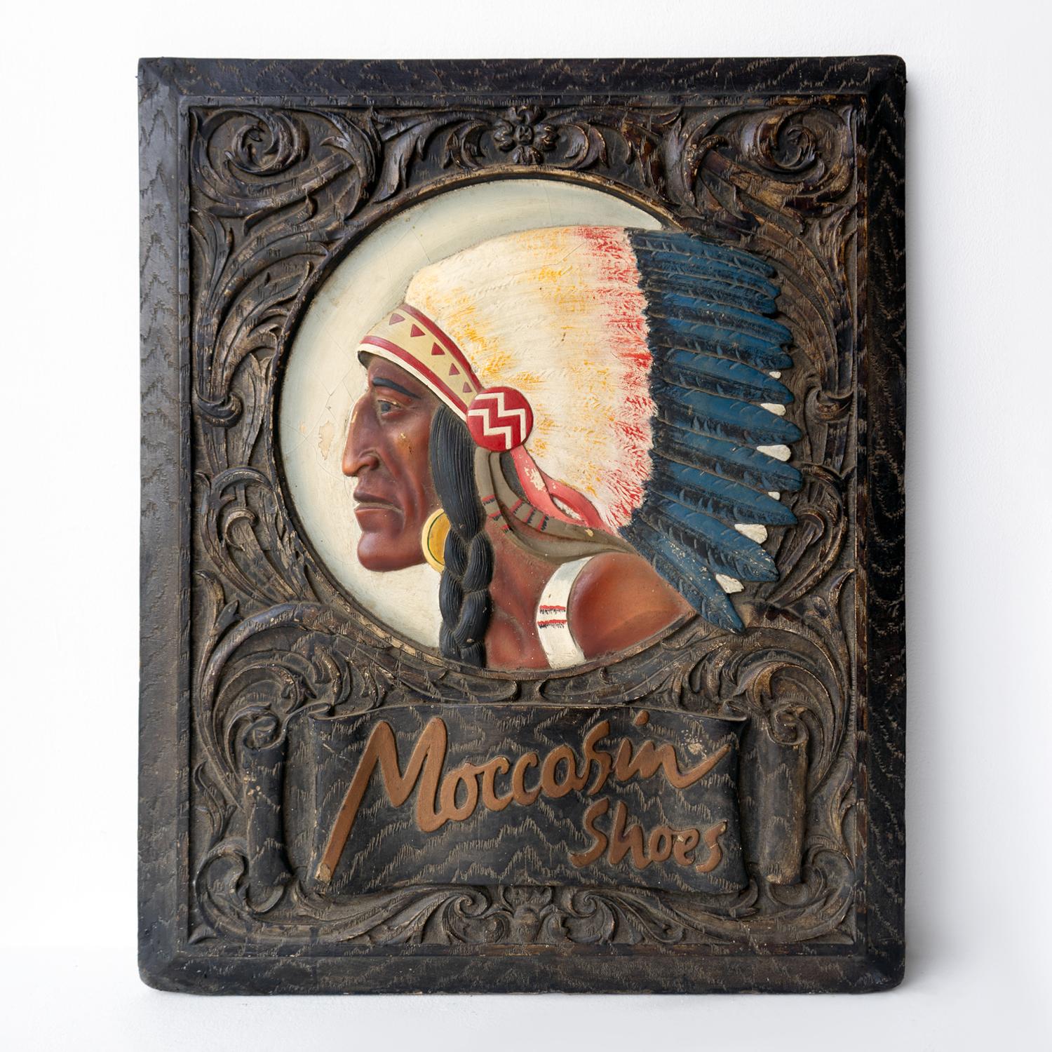 MID-CENTURY ADVERTISING SIGN

Made from cast plaster and then expertly hand-painted to emulate a carved wooden panel with a central portrait of a Native American Chief in profile wearing a feather headdress.

Gold lettering underneath advertises the