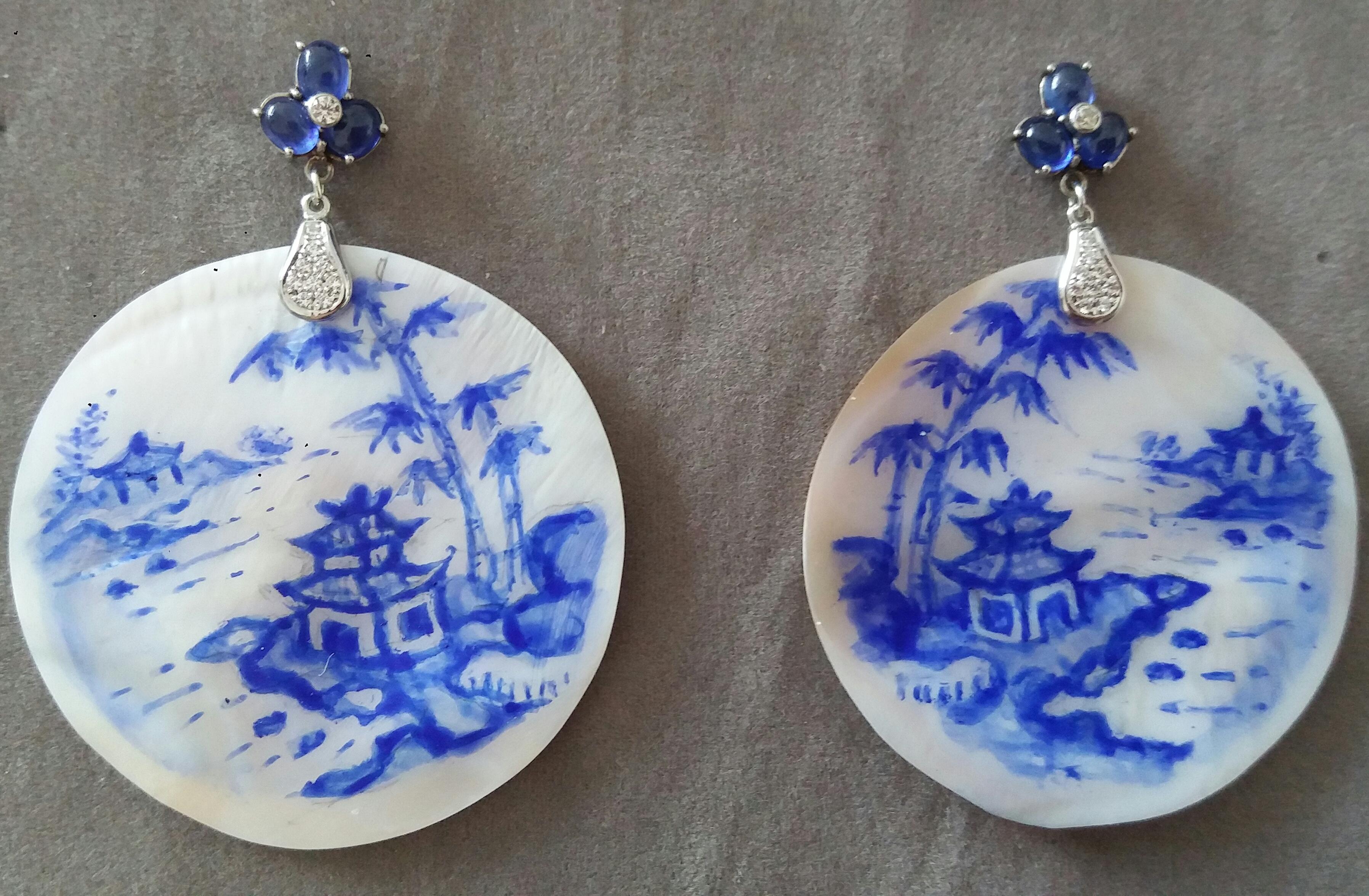 Vintage pair of hand painted round shape Mother of Pearls  measuring 48 mm in diameter depicting a landscape with a chinese style house near bamboo canes near the river,suspended from a top composed by 3 Blue Sapphires with a small diamond in the