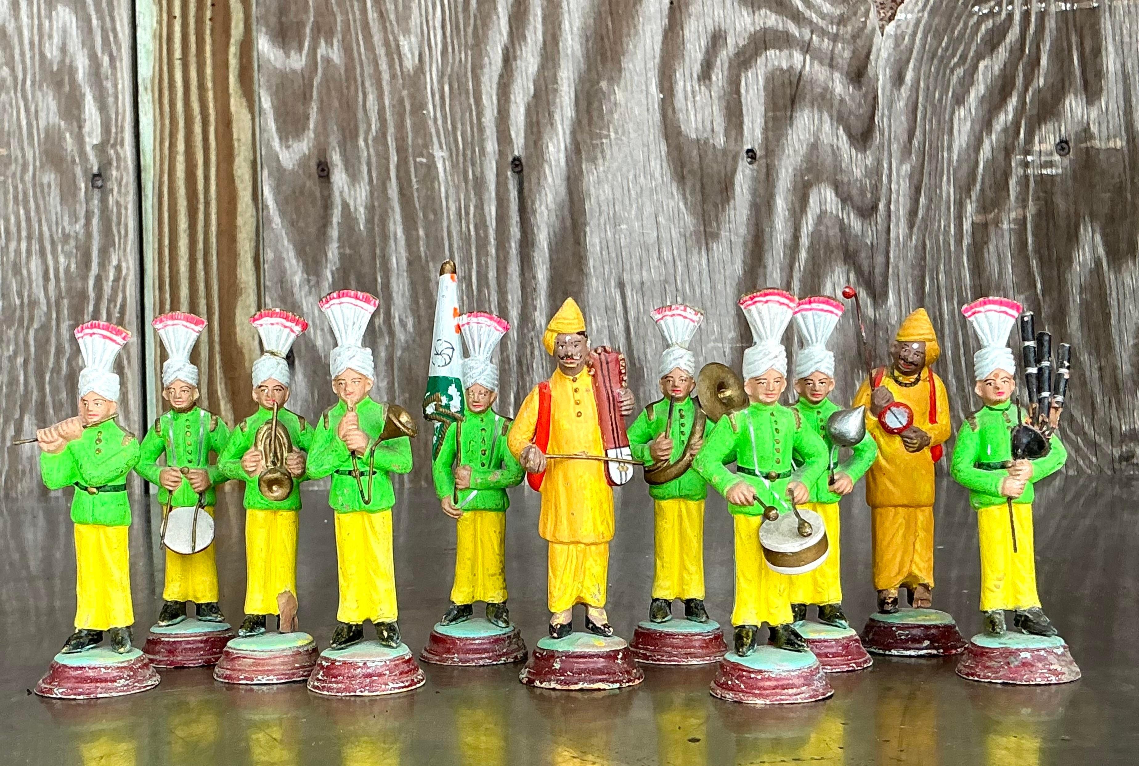 Questo affascinante set vintage per banda musicale in terracotta dipinta a mano presenta un'impressionante collezione di 11 figure vivaci. Tutti i membri di questa vivace band indossano giacche verdi e pantaloni gialli, sormontati da intricati