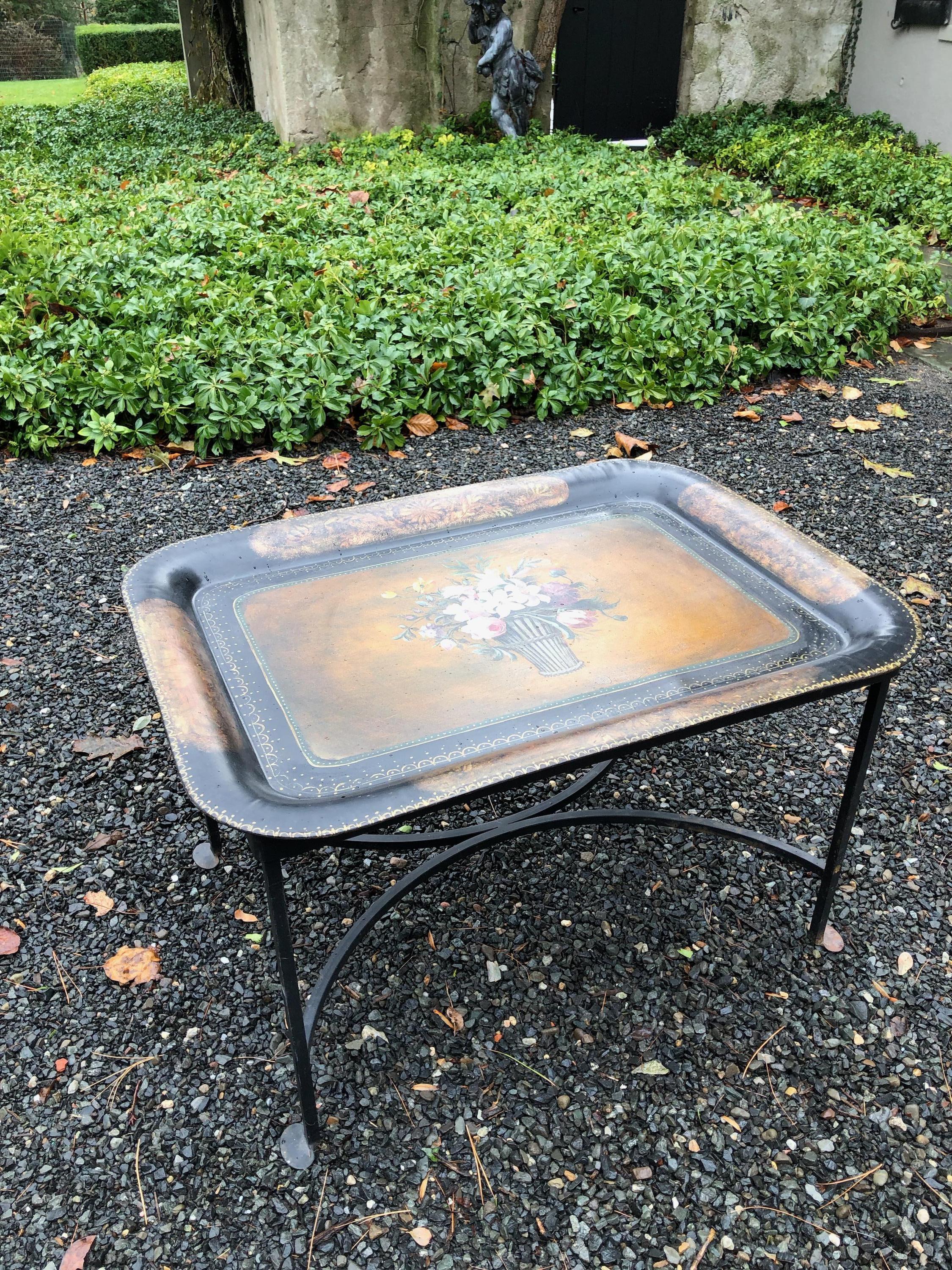 Vintage hand painted tole tray coffee table having an inset tray in a custom hand forged black iron base. The tray has rolled edges and back is in black paint with no markings. The base is new. The tray measures 28.25” wide x 21” deep x 1.5” tall.