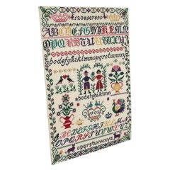 Vintage hand-stitched cross stitch alphabet sampler featuring multiple alphabet.