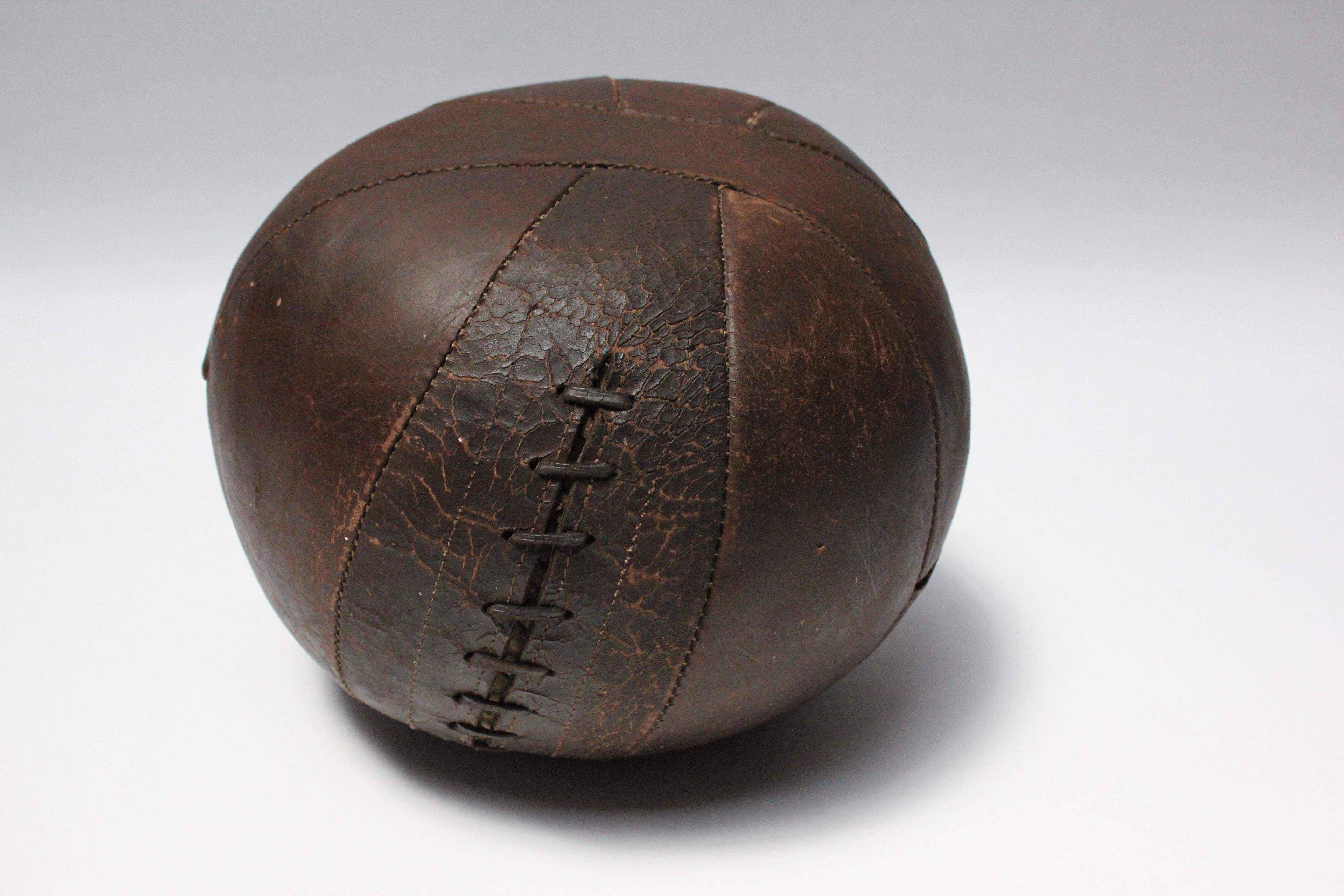 Circa 1920s 4-lb medicine ball retaining its original leather lacing. Beautiful patina / signs of natural age in chocolate-brown leather.
Measures: Height: 10.75