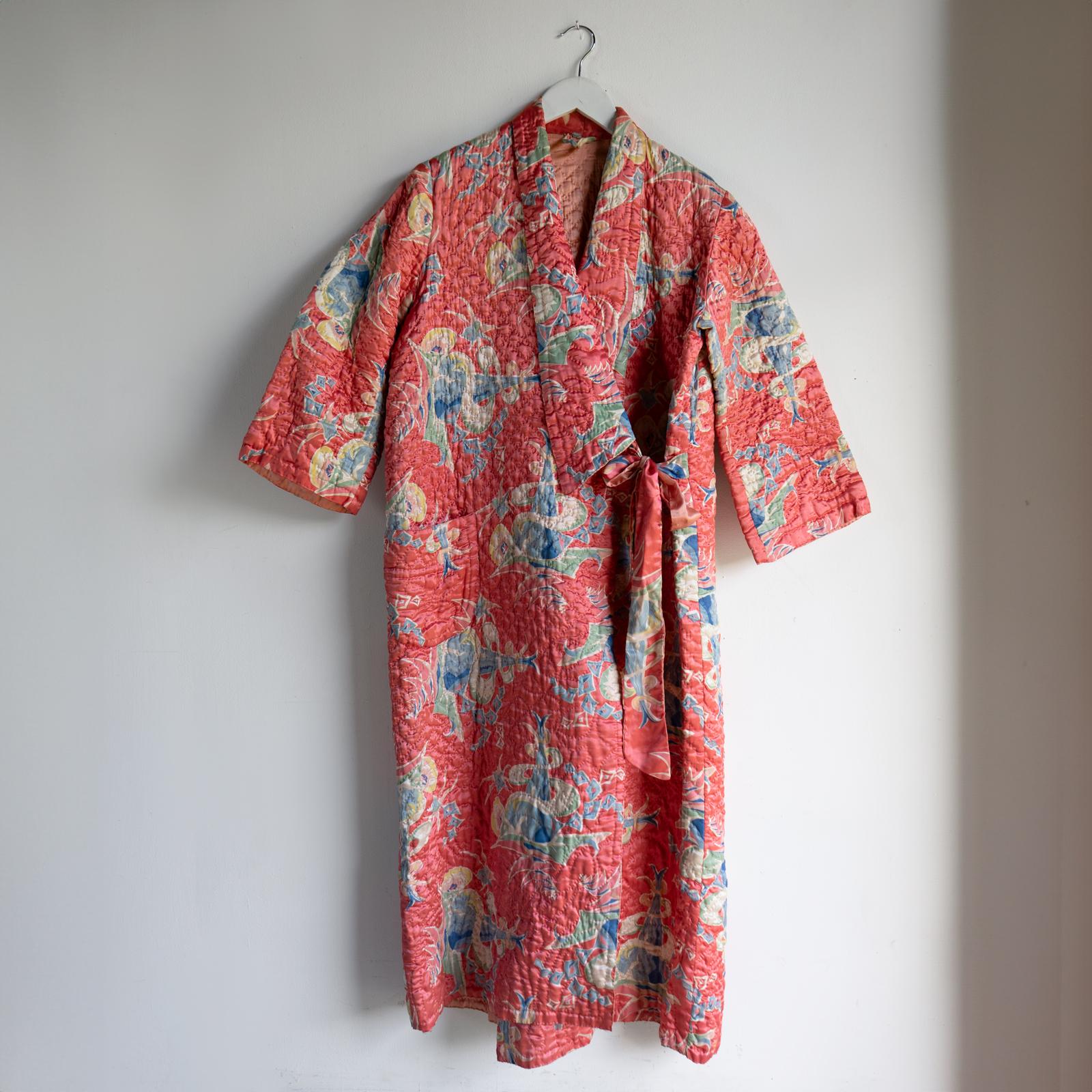 VINTAGE QUILTED HOUSE COAT 

A lovingly handmade item, with completely hand-stitched quilting techniques, a more standard criss-cross stitching on the upper, developing into fancy swirling patterns towards the bottom. 

An unusual graphic print