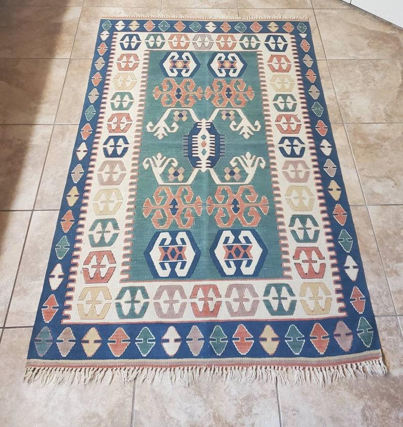 A beautiful hand-tied vintage Turkish Oushak Kilim rug. Original, authentic, circa 1960s; Turkey. 

Largely symbolic, the meanings expressed in kilims derive both from the individual motifs used, and by their pattern and arrangement in the rug as