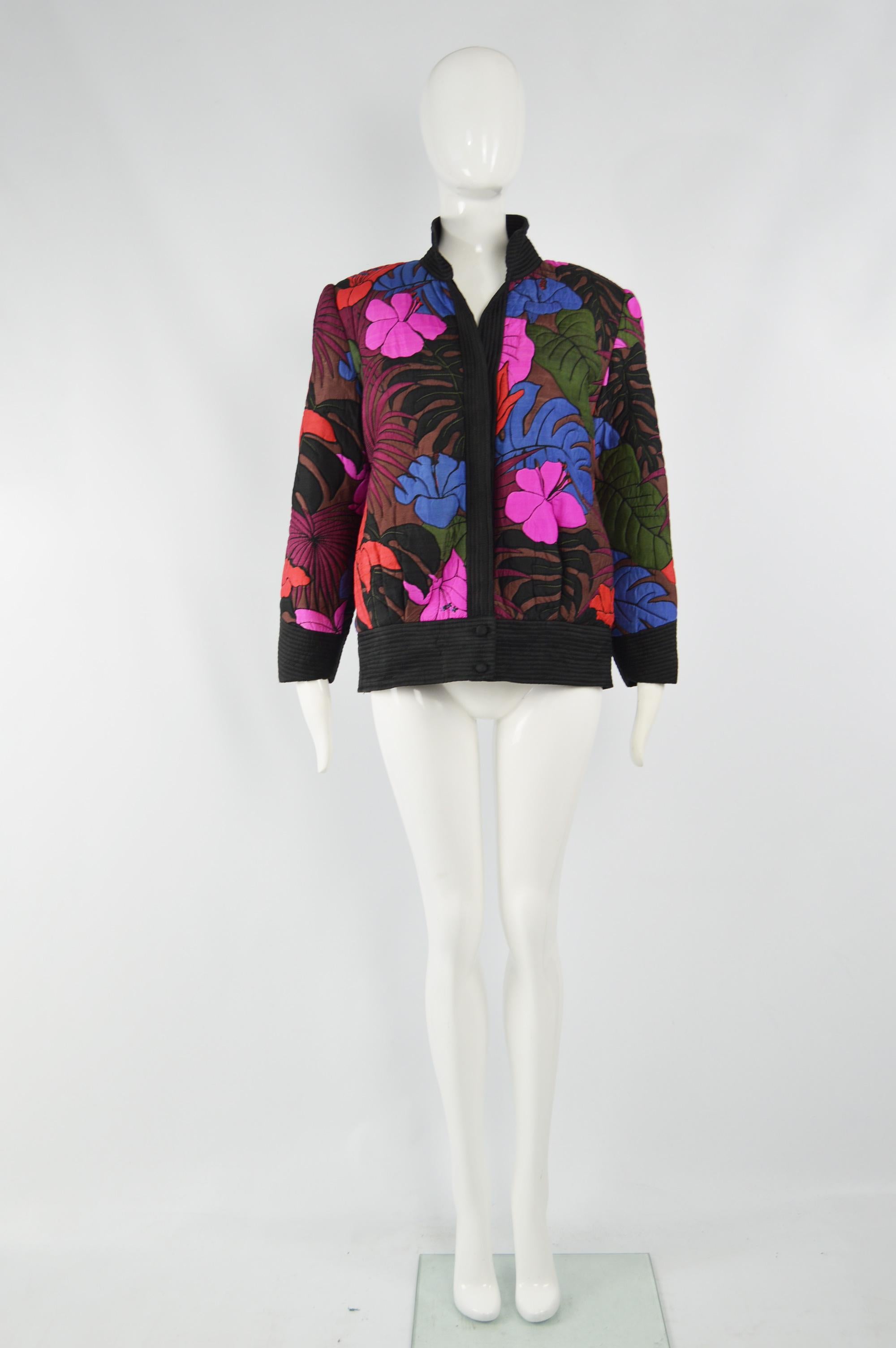 A beautiful vintage womens jacket from the 80s made from a colorful pure Thai silk with lightly hand worked quilting to create a textured, floral effect. It has no closures and is meant to nonchalantly drape open. It has shoulder pads which add to