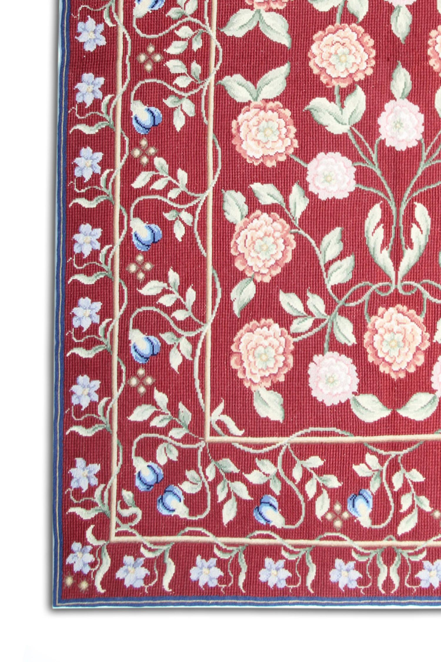 Ce tapis d'Aubusson magnifiquement tissé à la main est sûr de constituer une pièce d'accent dans n'importe quelle pièce où il est introduit. Un rouge profond sert de couleur de fond, qui a ensuite été décoré d'un arrangement floral symétrique rose,