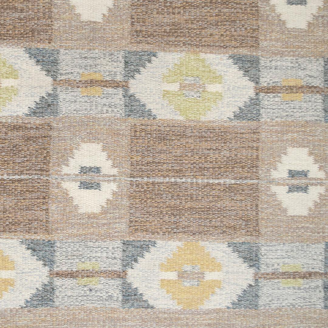 Dieser handgewebte schwedische Teppich im Vintage-Stil hat ein verwittertes braunes Feld mit horizontalen Reihen stilisierter grafischer Rauten, unterbrochen von anthrazitfarbenen Paneelen und goldenen Akzenten, in einer schattierten braunen