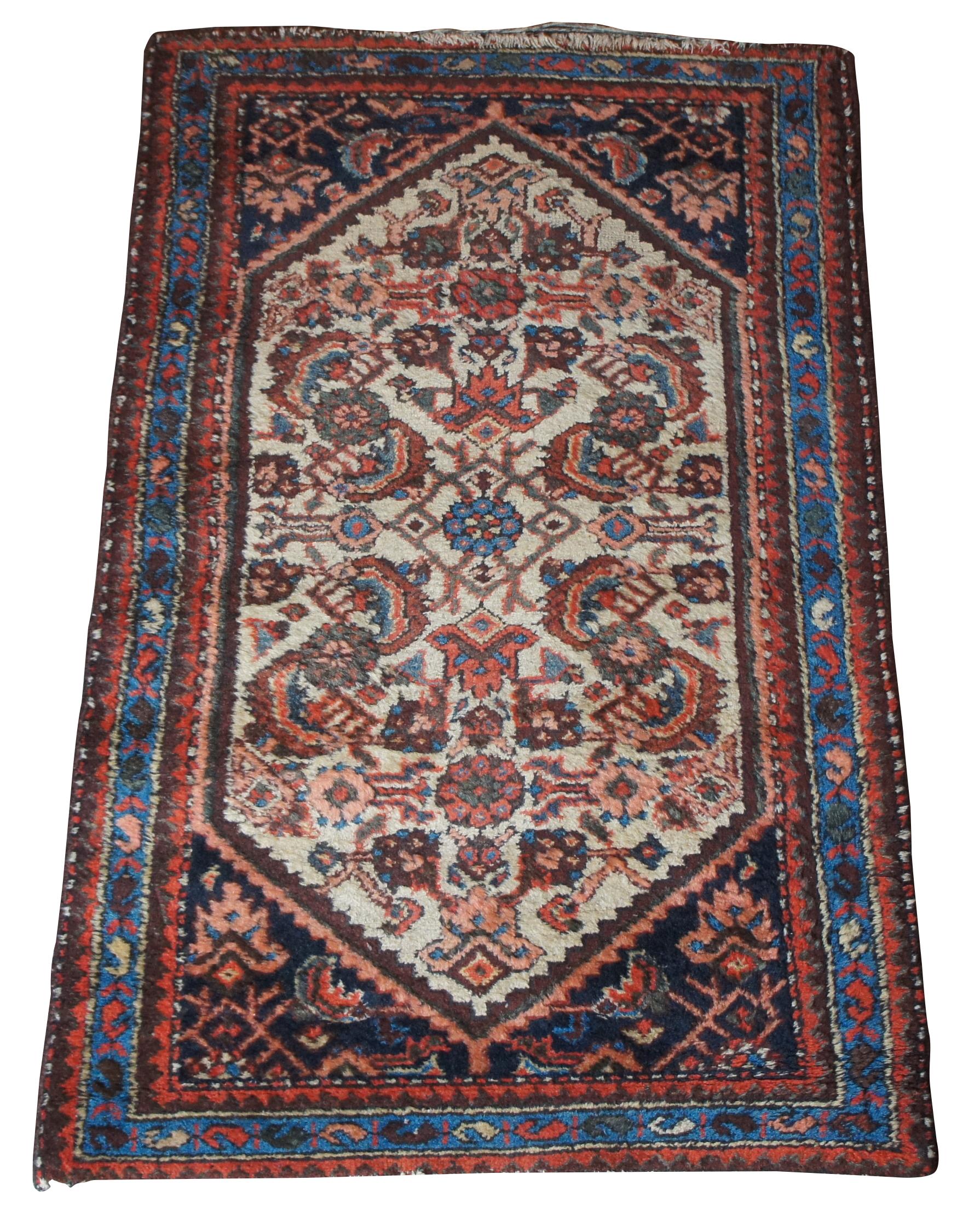 Semi antique hand knotted floral rug or mat. Made of wool featuring a floral motif over a tan field with geometric designs along the boarder. Pinks, blues, reds and tans. Made in Iran. Measure: 48