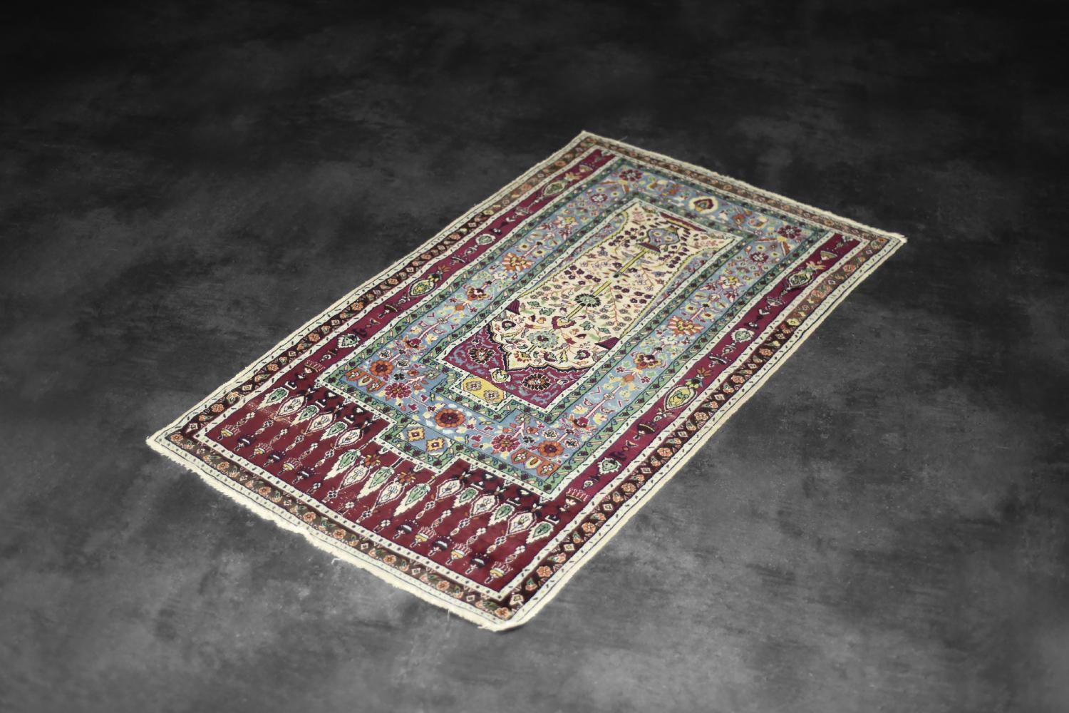 This hand-woven Baluch prayer rug was made in Iran during the 1960s. Woven using a traditional technique called flat weaving, and dyed in shades of red, beige, blue, green and turquoise. This rug has a richly decorated, distinct pattern with a