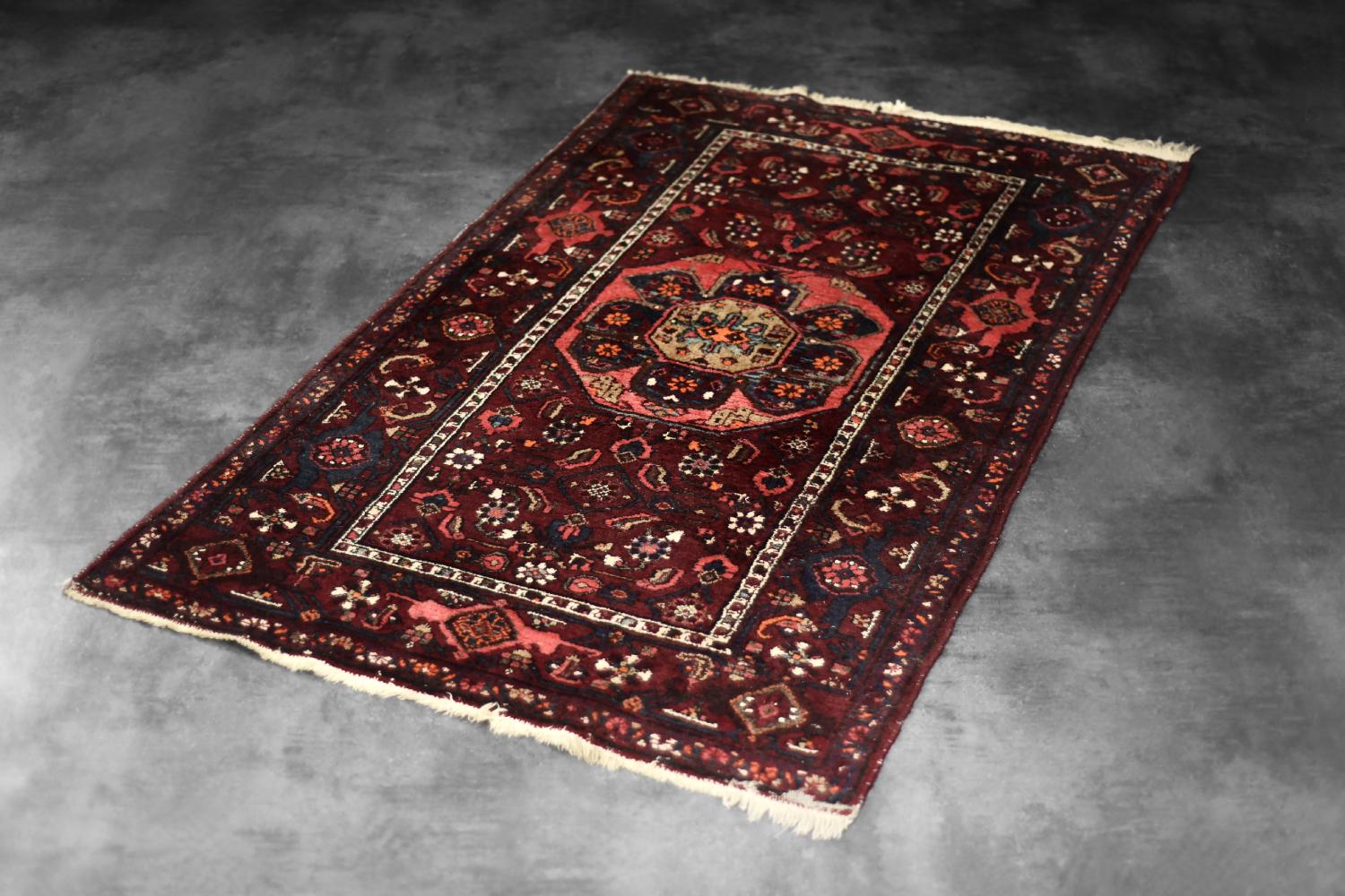 Ce tapis oriental noué à la main à Hamadan a été fabriqué en Iran dans les années 1960. Tissé à plat de manière traditionnelle et teint dans des tons de rouge rustique et de bleu indigo. Les tapis de Hamadan sont des tapis traditionnellement noués à