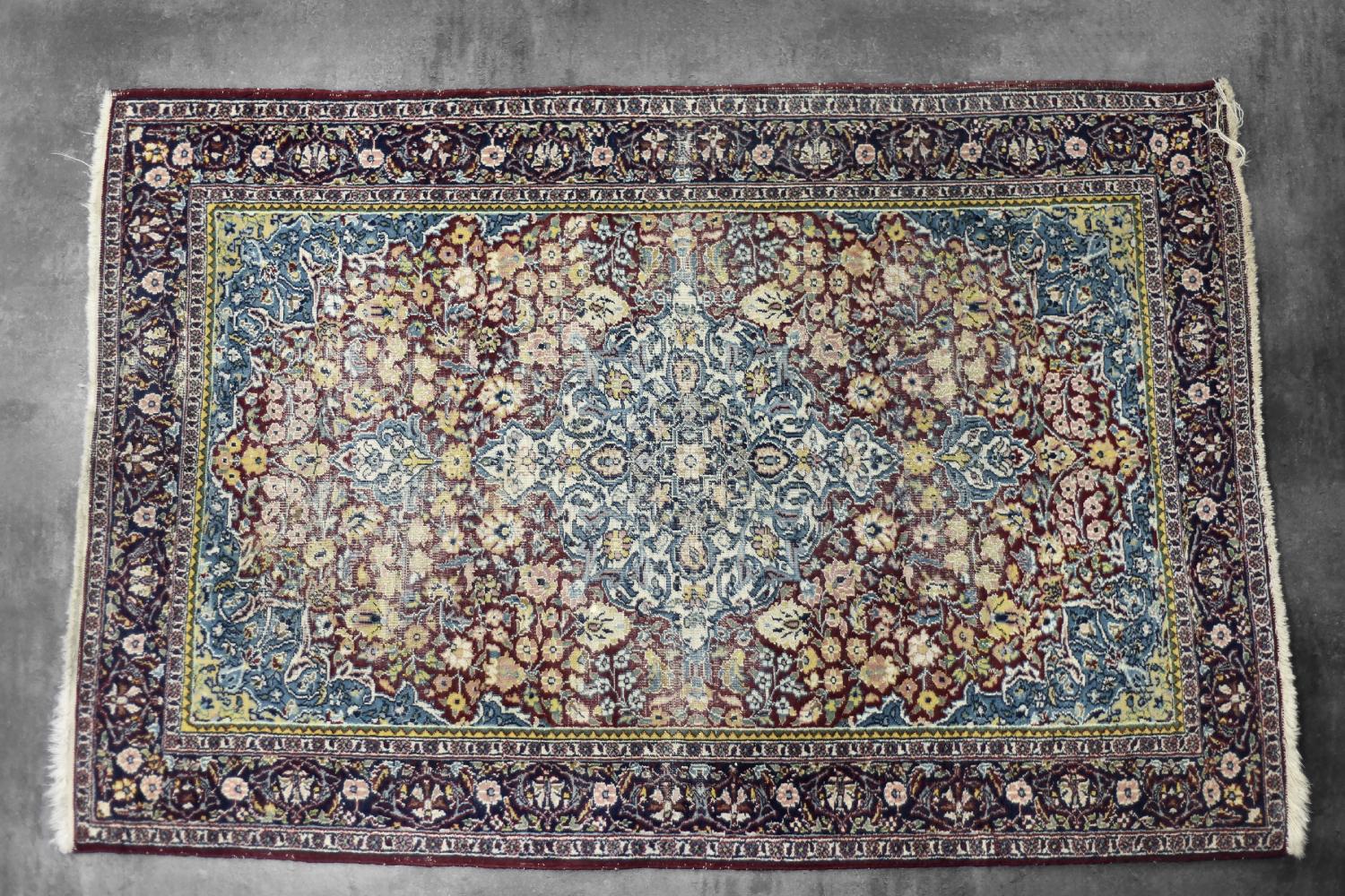 This hand-woven oriental Isfahan carpet was made in the city of Isfahan in central Iran, during the 1940s. It is naturally dyed in shades of deep red, blue and yellow. The colours intertwine in a distinct and varied pattern, the richness of which is