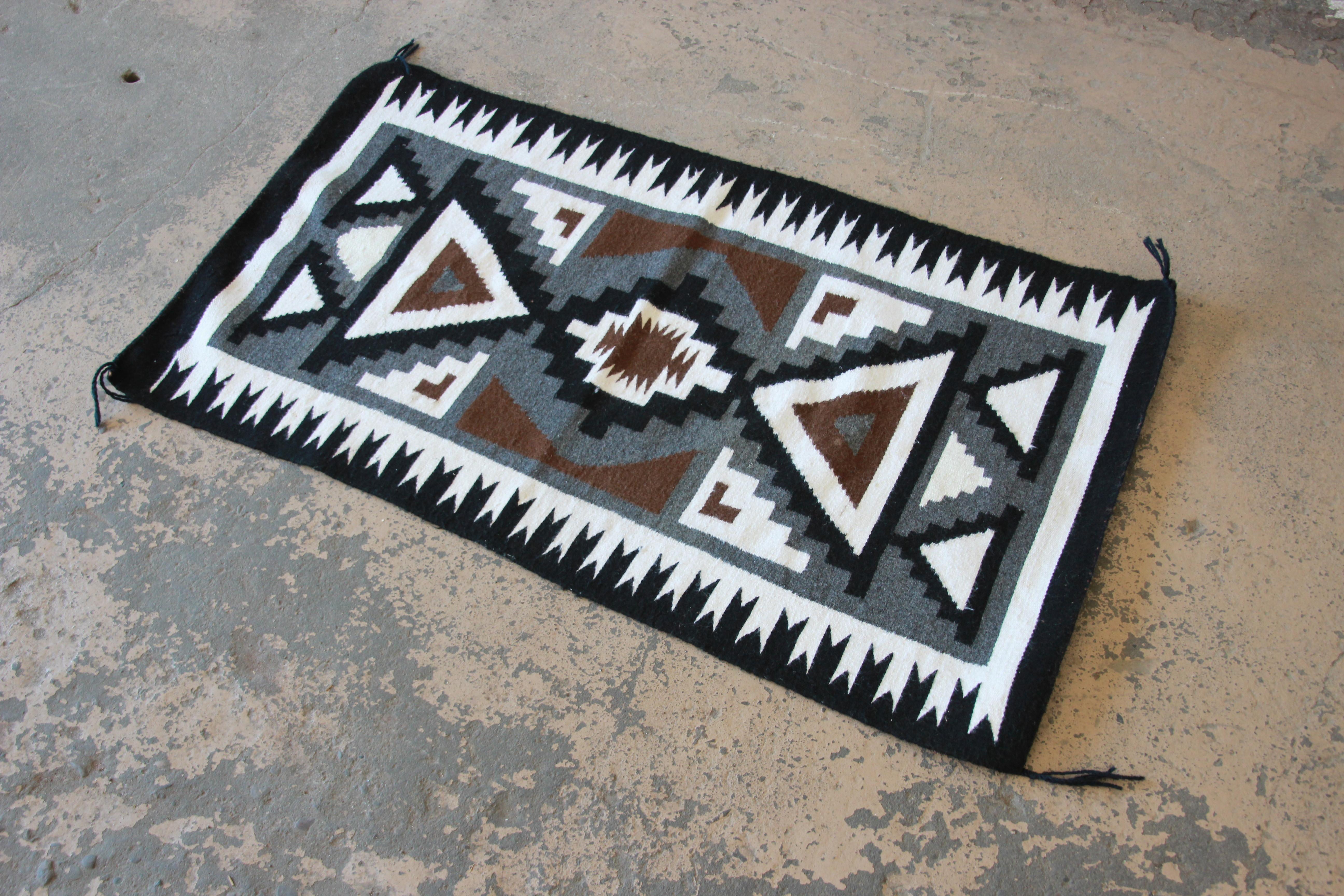 A gorgeous vintage authentic handmade Navajo Kilim wool rug

USA, Circa 1950s

Geometric design in black, white, brown, and gray.

Measures: 2