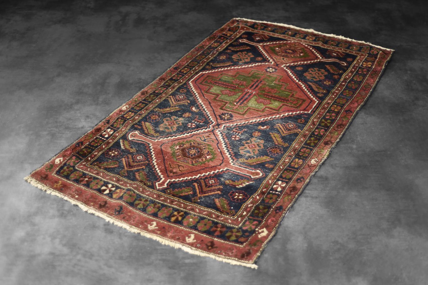 Questo tappeto Tribale Shiraz Qashqai tessuto a mano è stato realizzato in Iran negli anni Quaranta. Tinti nelle tonalità del rosso, del blu e del verde. Al centro del tappeto c'è un triplo medaglione geometrico. È un tipo di tappeto nomade, può