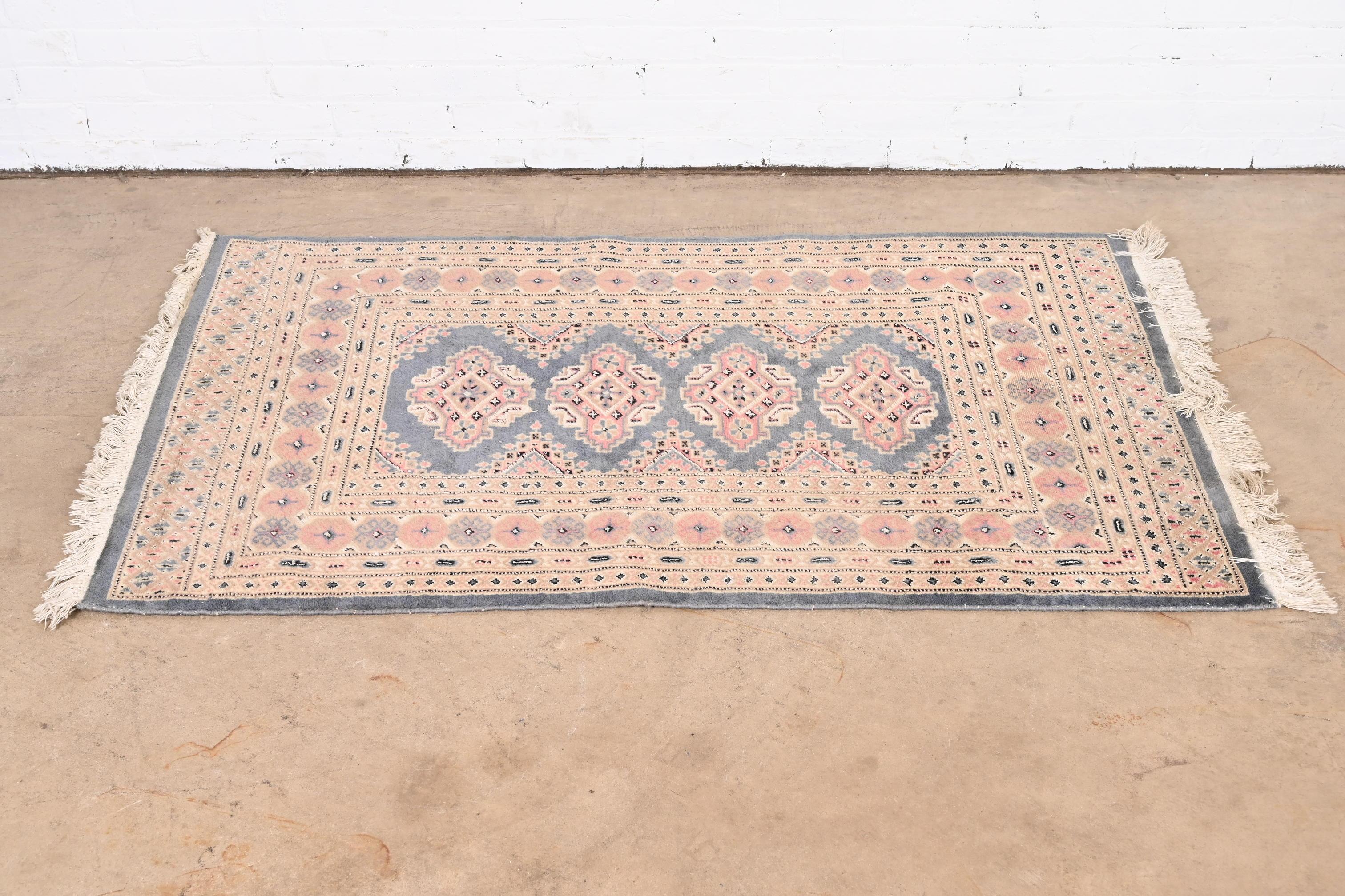A gorgeous vintage hand-woven Persian Bokhara wool rug

Mid-20th Century

Beautiful geometric design, with predominant colors in pink, blue, and cream.

Measures: 38