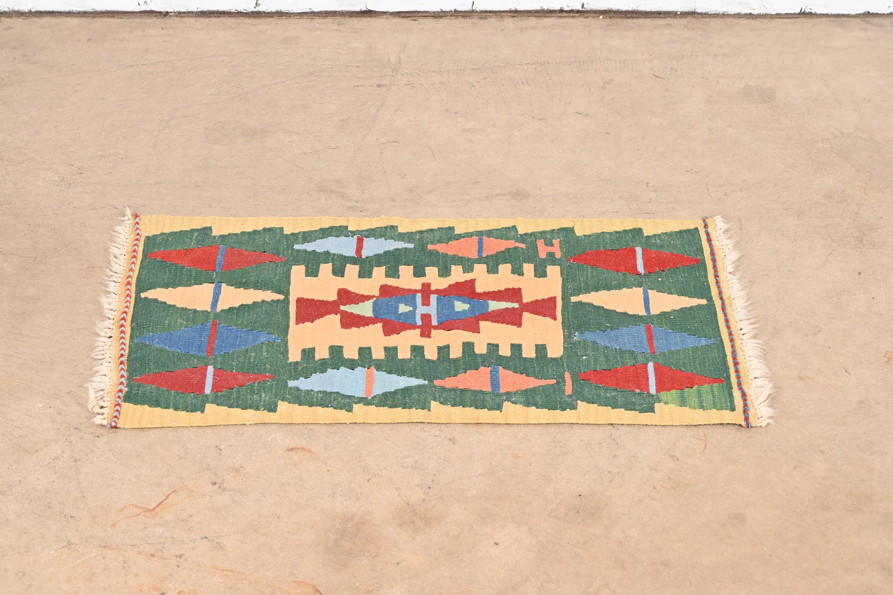 A gorgeous Mid-Century Modern hand-woven Persian Kilim flat weave rug

Mid-20th century.

Beautiful geometric design, with predominant colors in green, red, blue, and tan.

Measures: 20.75