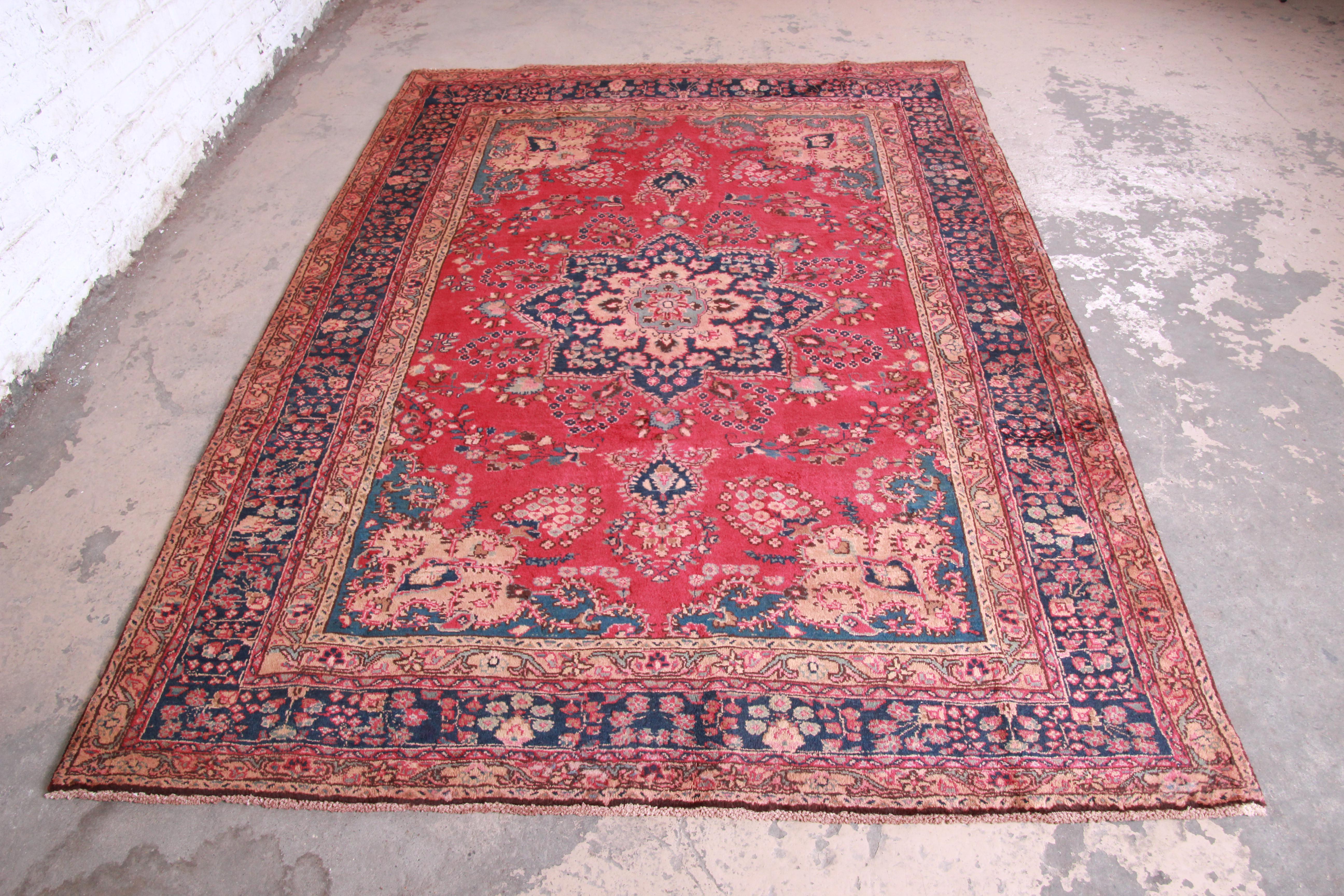 A gorgeous vintage handwoven Persian rug. The rug has a beautiful floral pattern with predominant colors in red, blue, green, and brown. The rug is clean and in very good condition, with very minor wear from age and use.

The rug measures 77.75