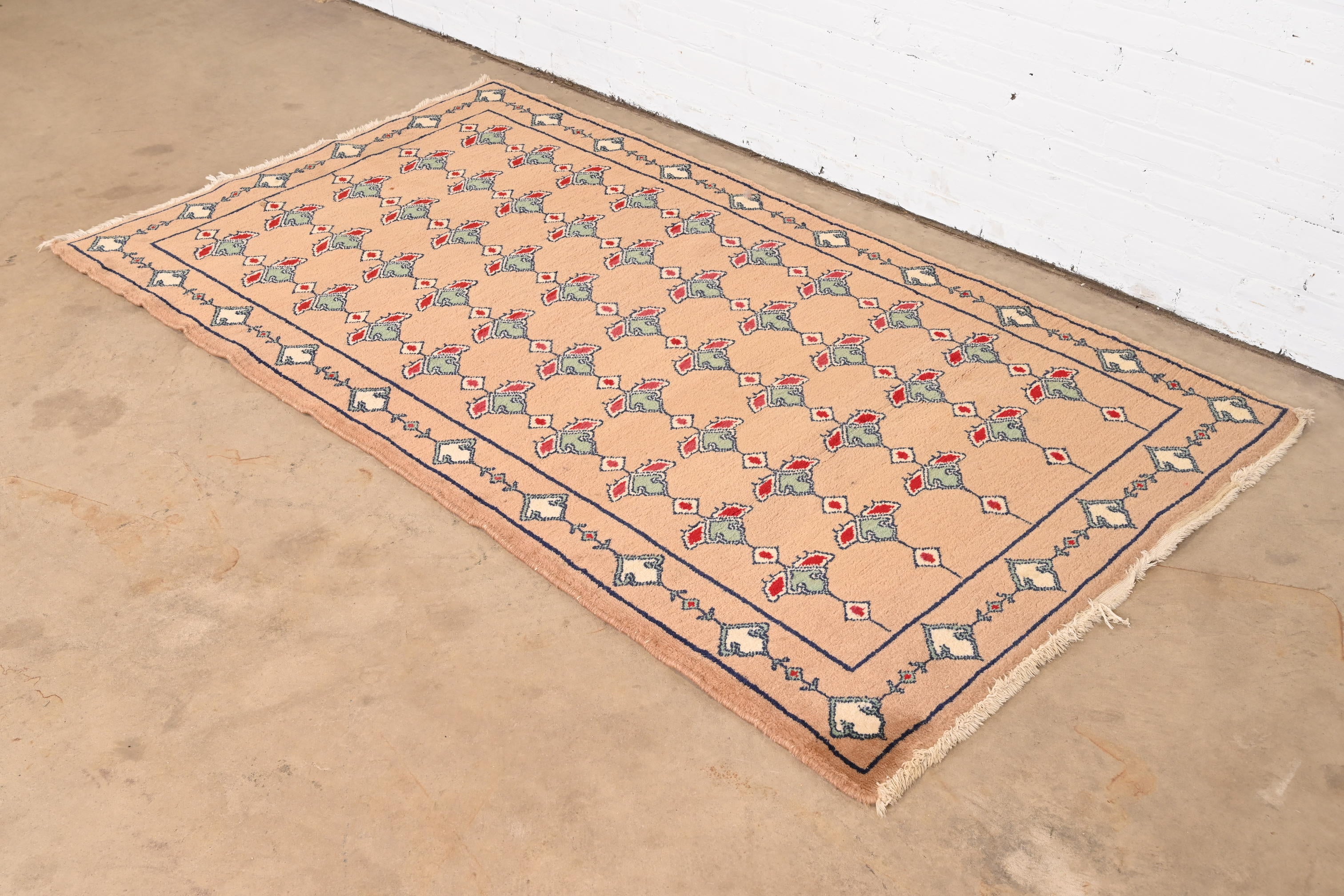 A gorgeous vintage hand-woven Persian wool area rug

Mid-20th century

Classic geometric design, with predominant colors in tan, green, red, and ivory.

Measures: 46