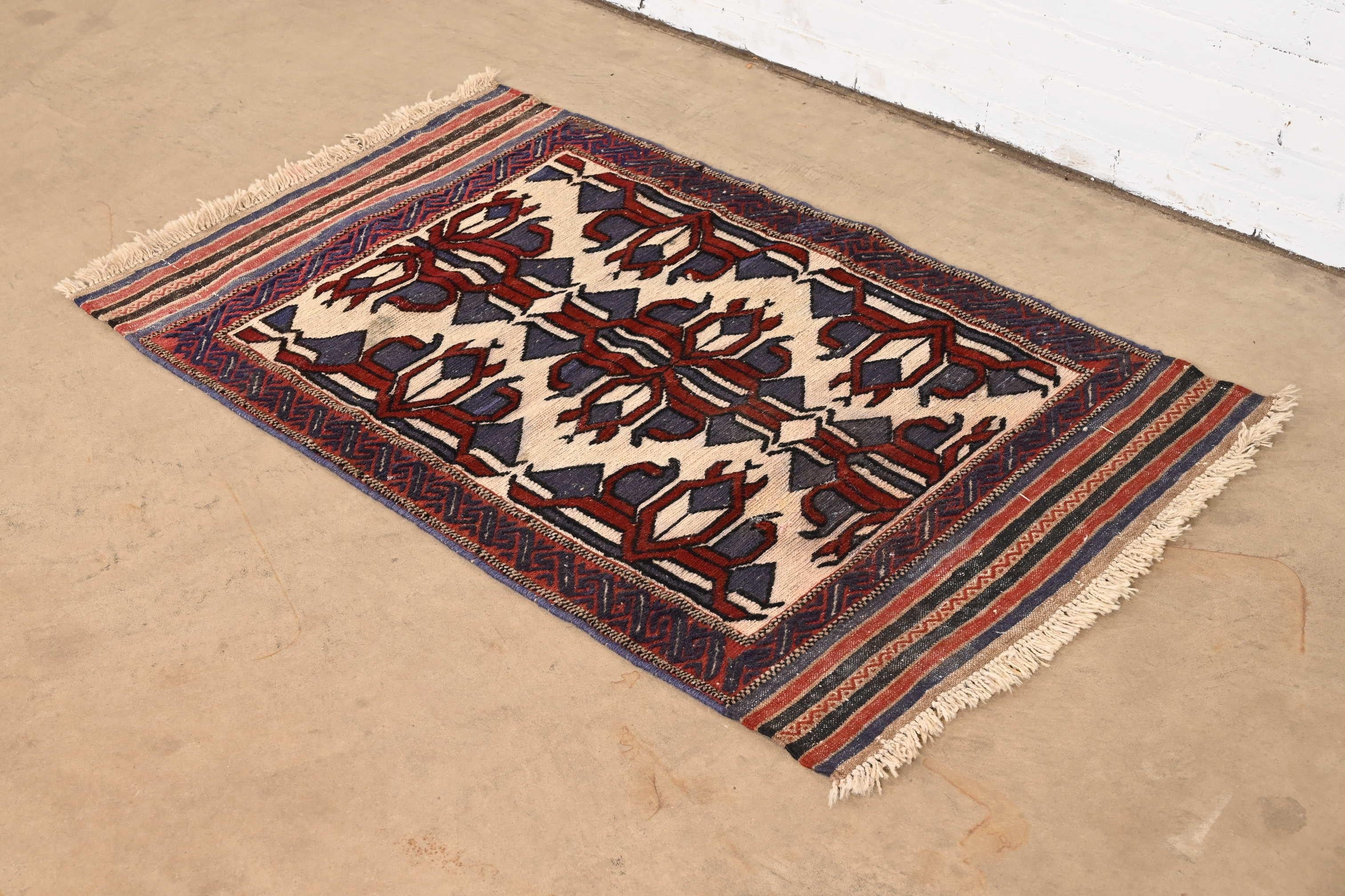 A gorgeous vintage hand-woven tribal Afghan Soumak wool rug

Mid-20th Century

Beautiful geometric design, with predominant colors in red, blue, and ivory.

Measures: 31