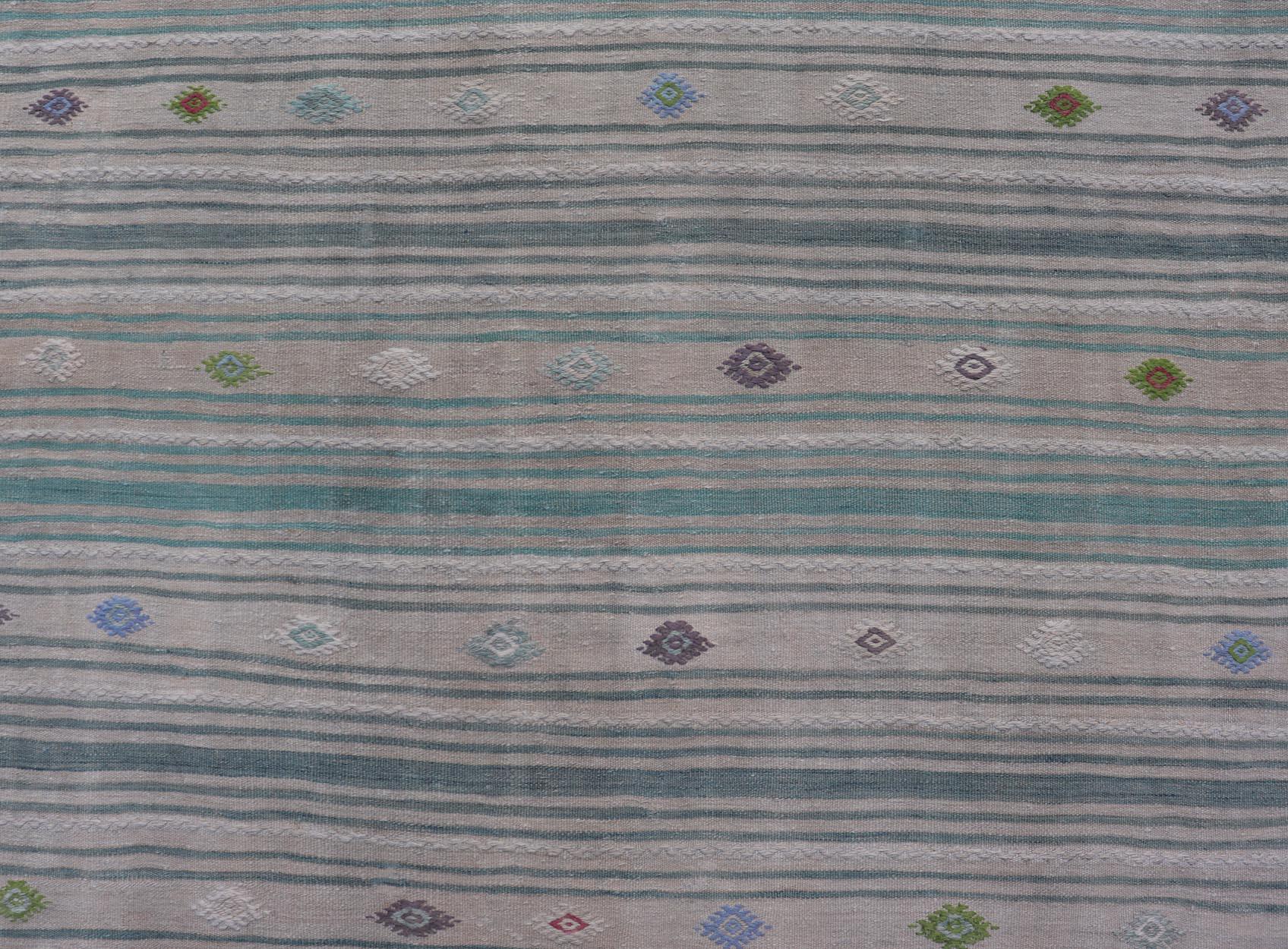 This flat-weave tribal Turkish kilim has been hand-woven in wool. The rug features an all-over sub-geometric striped design, and is rendered in multicolor; making this rug a superb fit for a wide variety of interiors.

Vintage Kilim Rug with