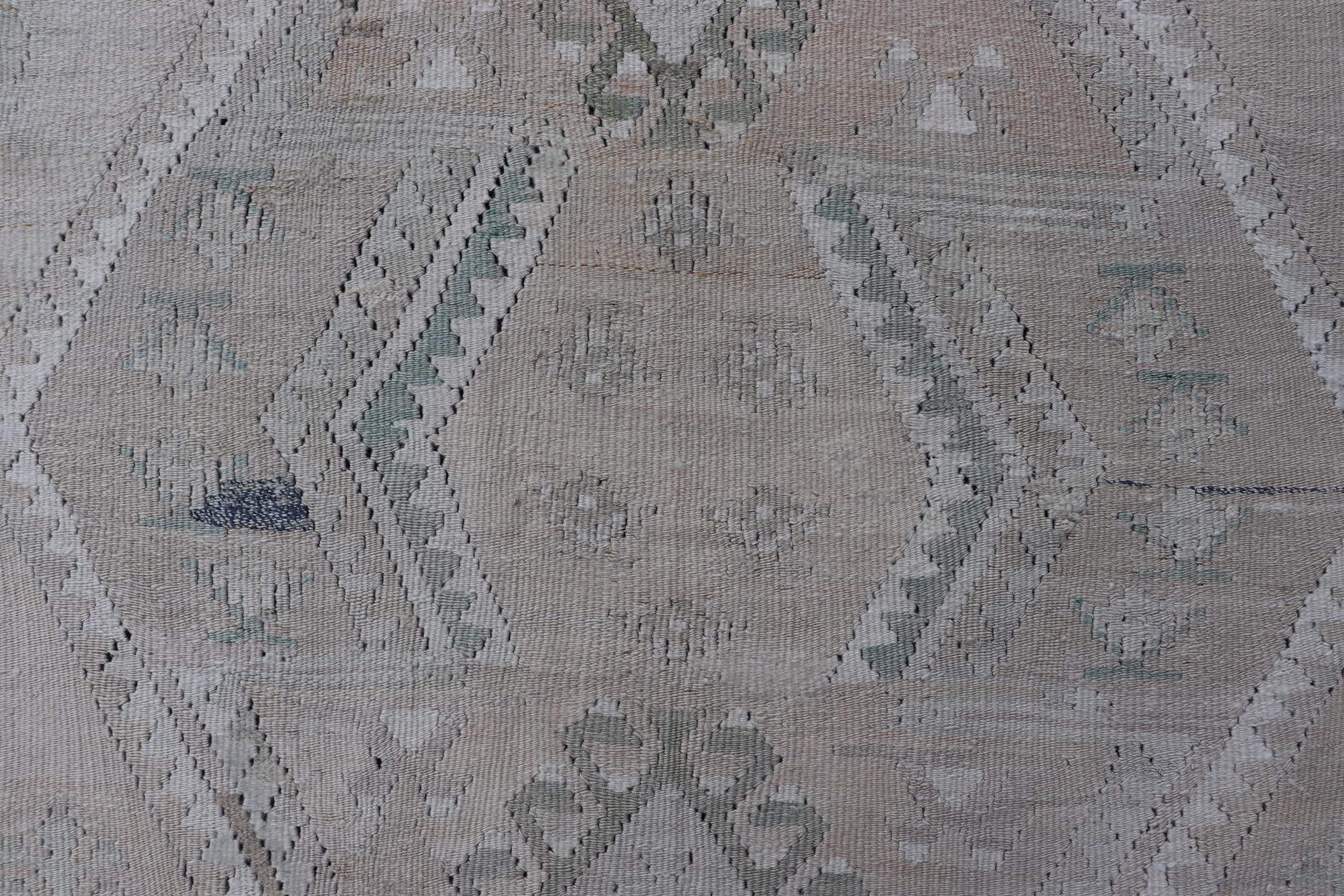 Dieser flachgewebte türkische Stammeskelim wurde von Hand aus Wolle gewebt. Der Teppich zeichnet sich durch ein subgeometrisches Medaillonmuster aus, das in Grün-, Blau- und Neutraltönen gehalten ist und sich hervorragend in eine Vielzahl von