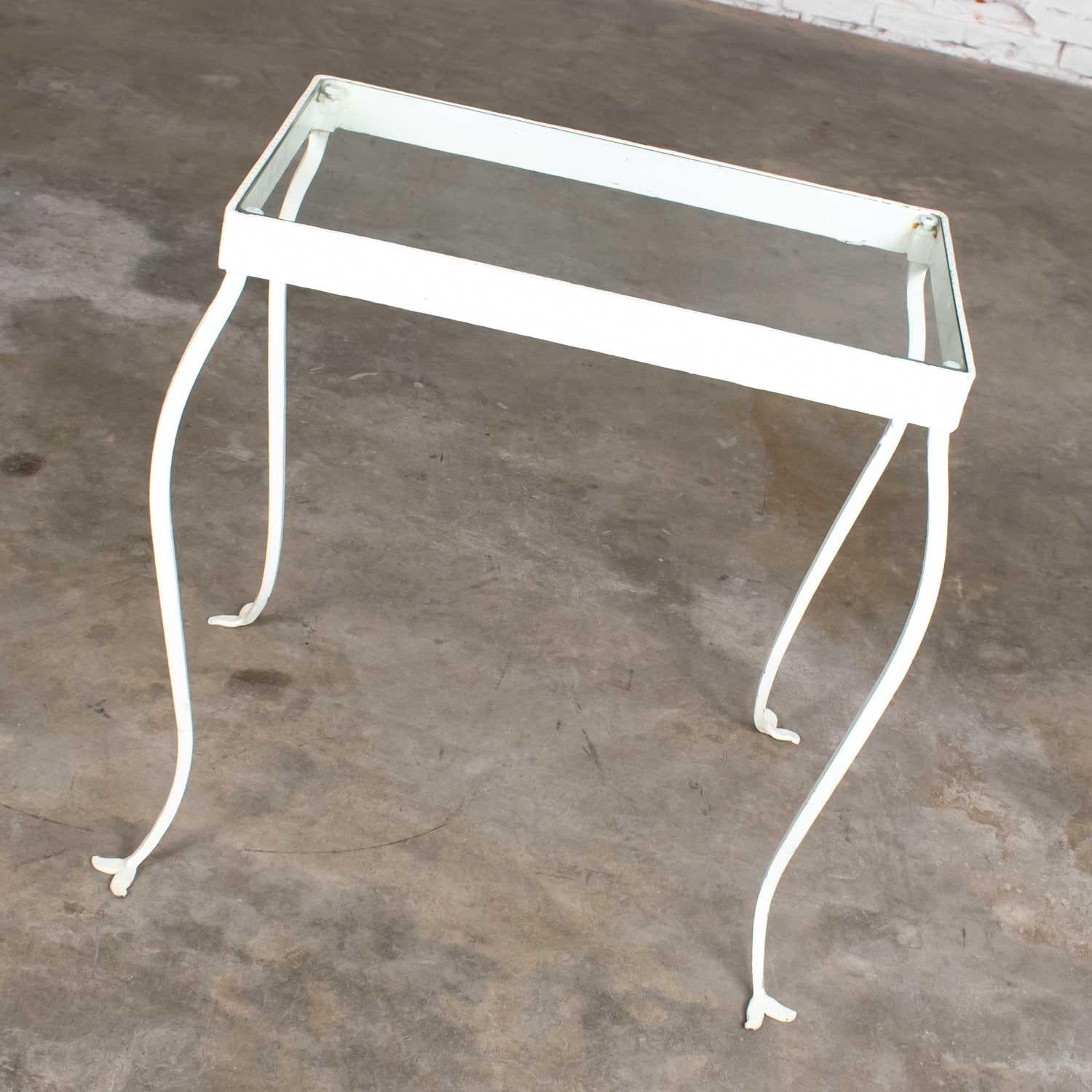 Classic handwrought iron rectangle side table with glass top. Hand painted white with bent wrought iron legs. Beautiful vintage condition. Please see photos, circa early to mid-20th century.

Simply beautiful is how we describe this hand wrought