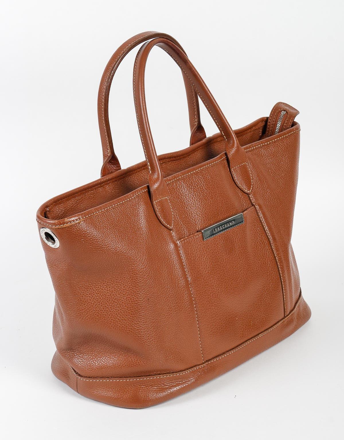 Vintage Handbag, Longchamp, Light Brown Leather, XXth century.

Longchamp handbag, light brown leather, chromed metal plate with the brand, good condition, XXth century.    
h: 23cm , w: 40cm, d: 17cm