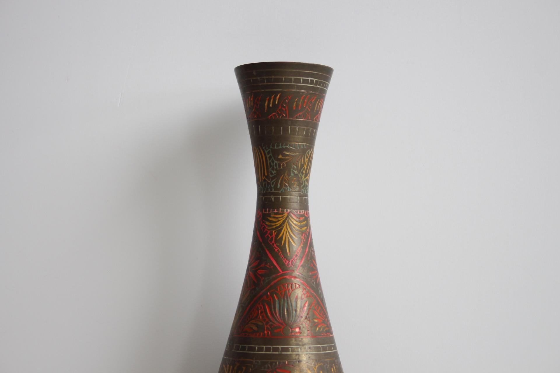 Eleva i tuoi interni con questo squisito vaso in ottone lavorato a mano e proveniente dall'India. Alto con un collo graziosamente svasato e una base ampia, questo pezzo mostra notevoli dettagli artigianali. La superficie è ornata da motivi floreali