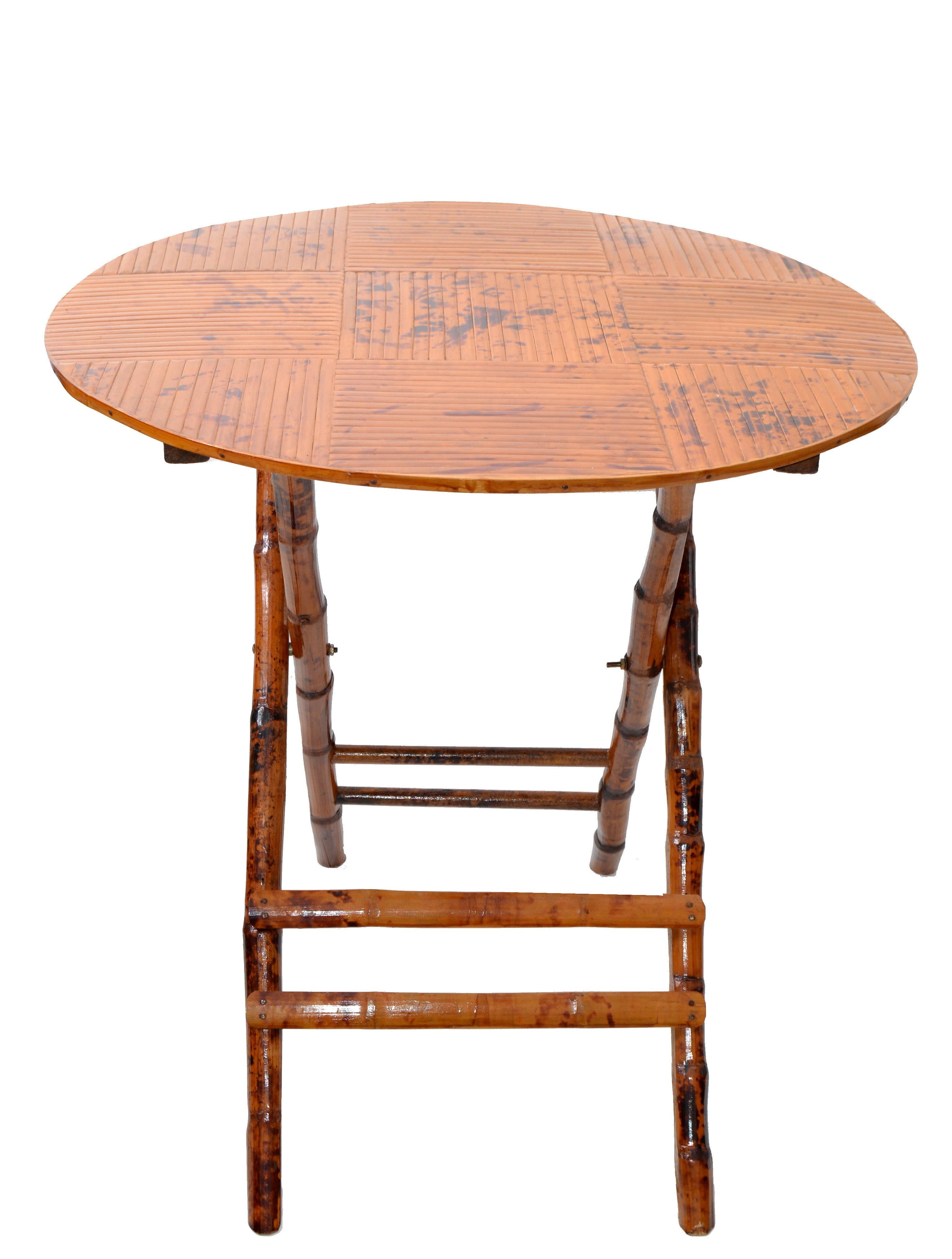 1970s Mid-Century Modern handcrafted round bamboo bistro table.
Decorative and sturdy X-base.
The table is easy to fold and uses a small storage place.