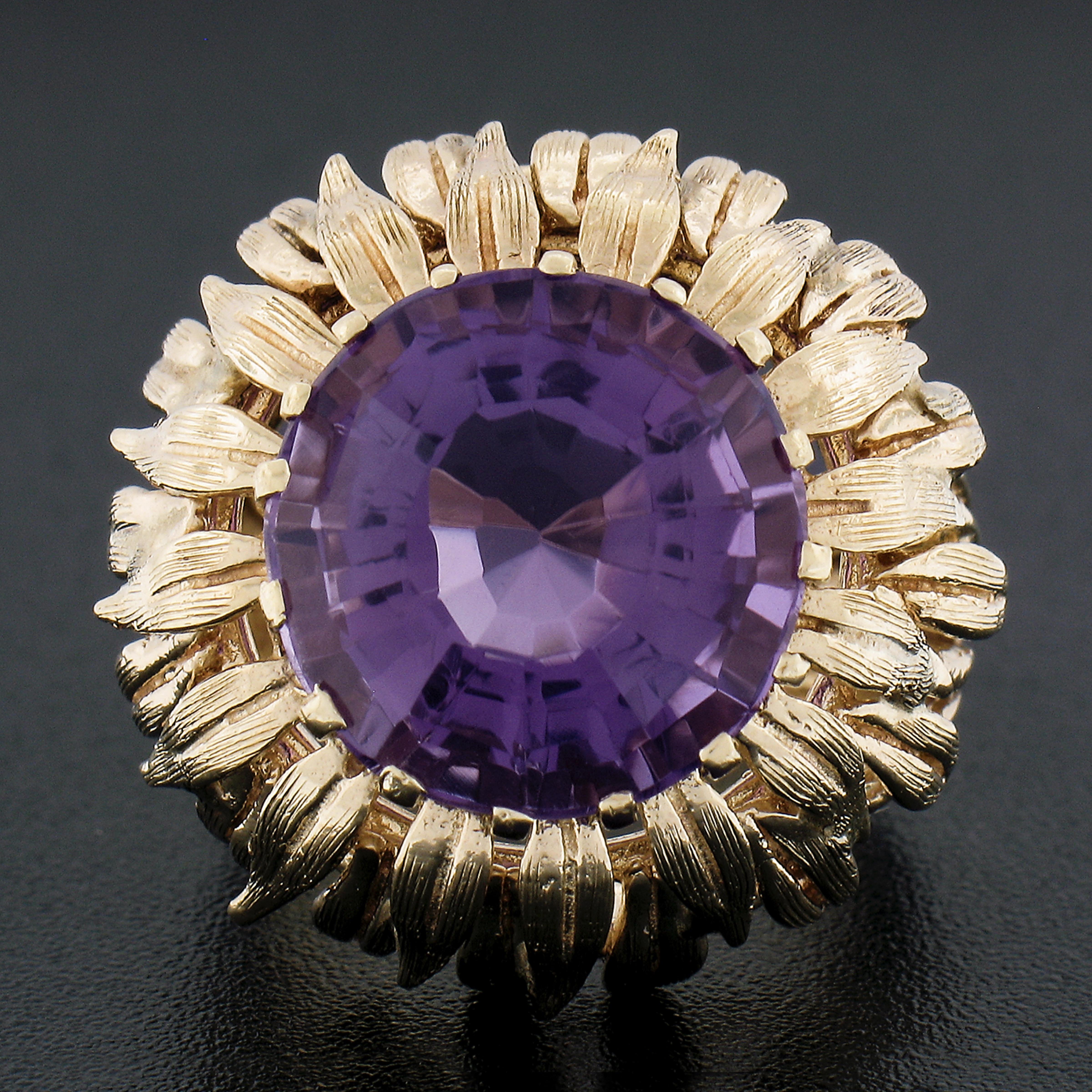 --Stone(s):--
(1) Natural Genuine Amethyst - Round Step Cut - Multi Prong Set - Medium to Dark Purple Color - 13.8mm (approx.)

Material: Solid 14K Yellow Gold
Weight: 13.93 Grams
Ring Size: 7.0 (Fitted on a finger. We can custom size this ring. -