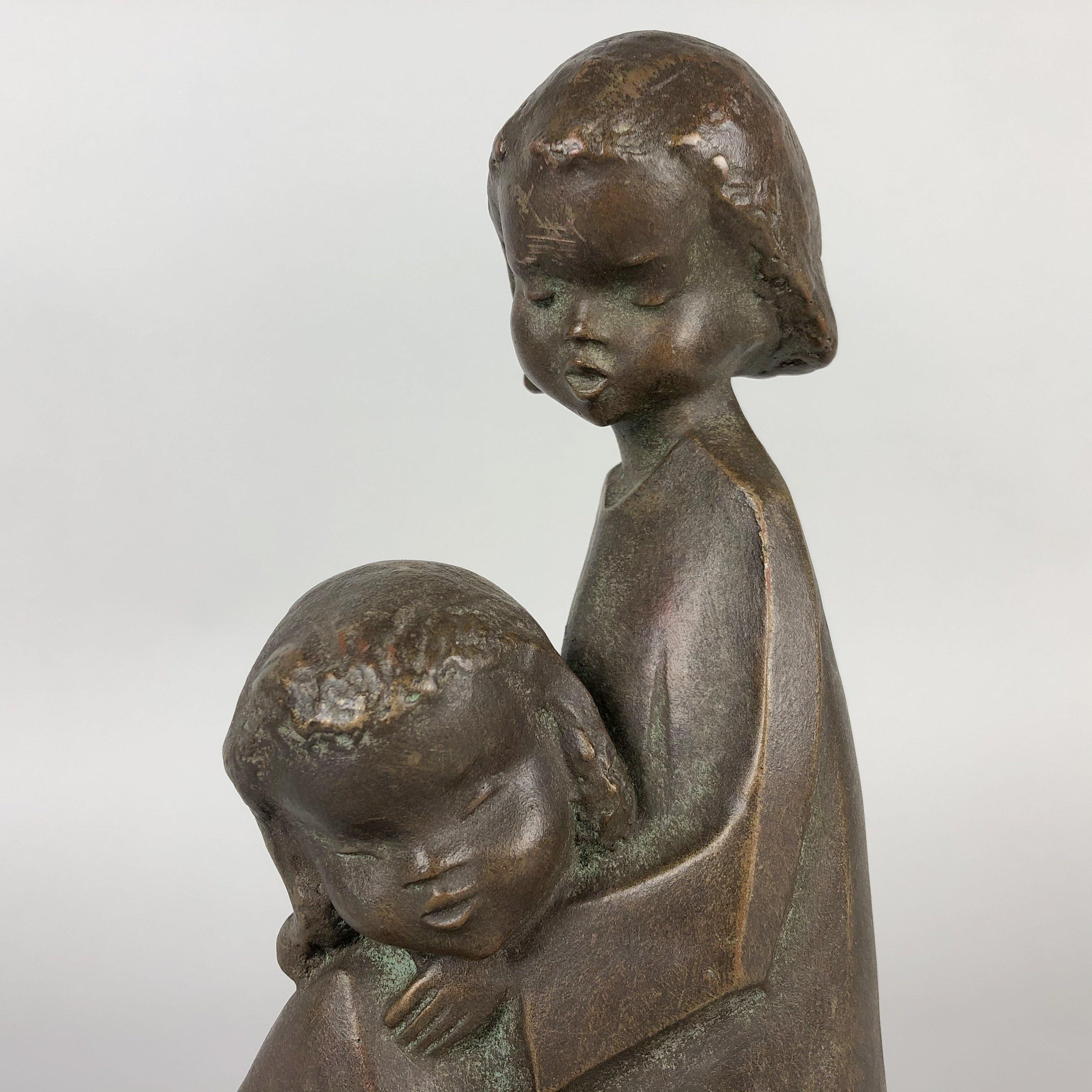 Vintage achatit sculpture depicting two children. Bronze look. It is very light.
Achatit is a non-ceramic material registered trademark of the company, made by boiling fine powdered stone with sawdust and a binding agent which is poured into a