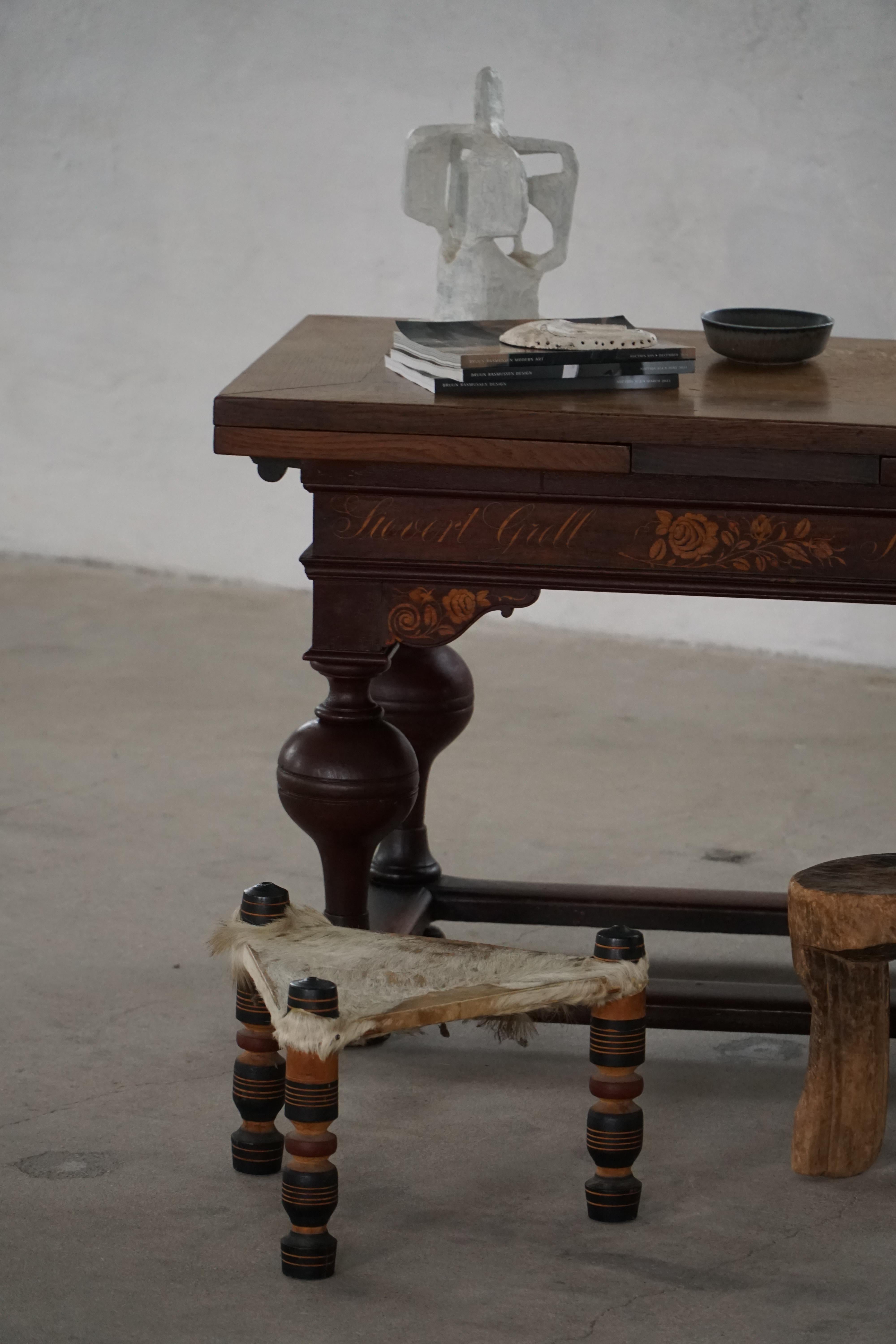 A rare and beautoful vintage African stool, handcrafted from natural cowhide and painted wood. This three-legged triangular stool exemplifies traditional tribal craftsmanship, where functionality and artistry are seamlessly combined. The long-haired